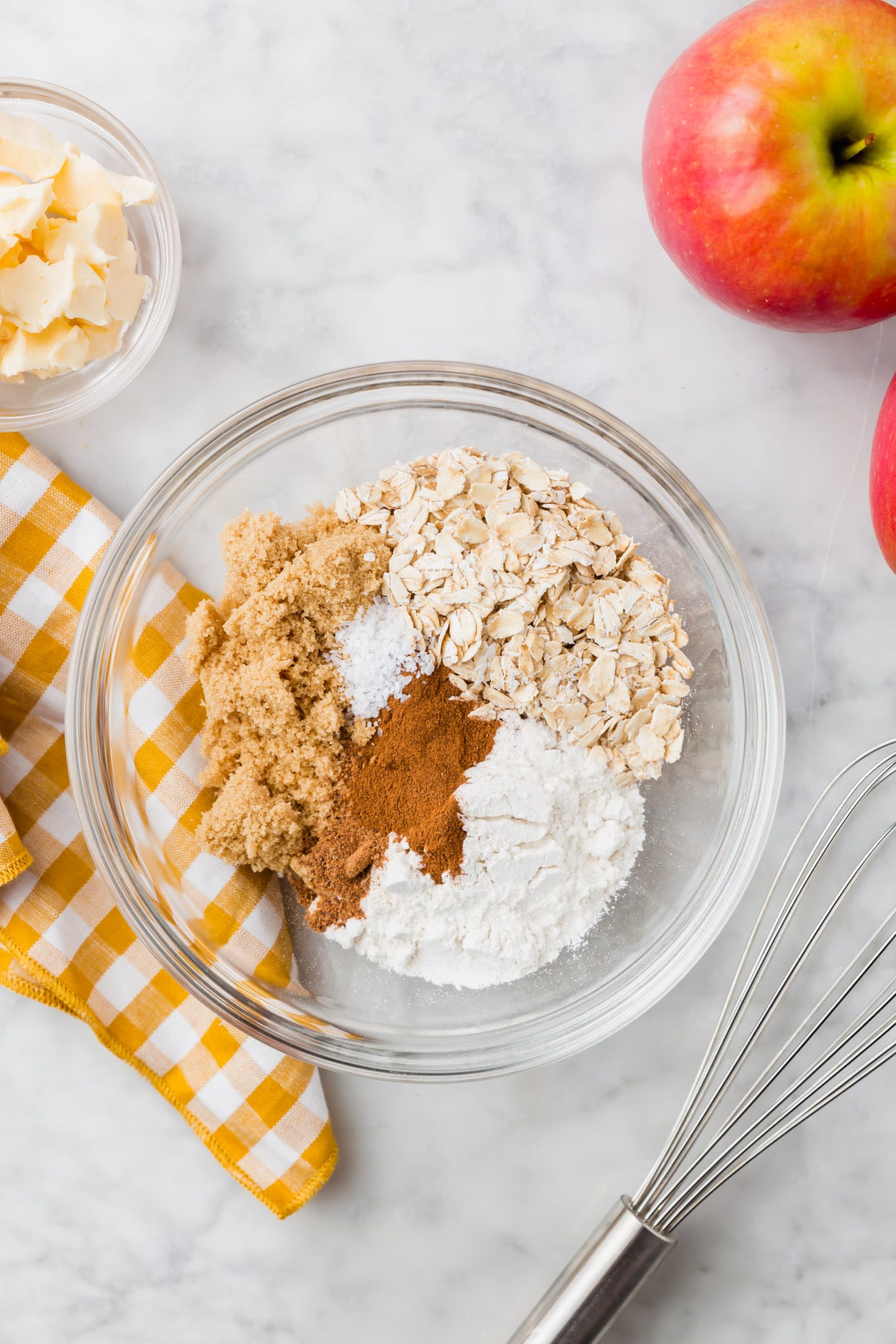 An overhead photo of a bowl with brown sugar, gluten-free oats, gluten-free flour, cinnamon, nutmeg, and salt.