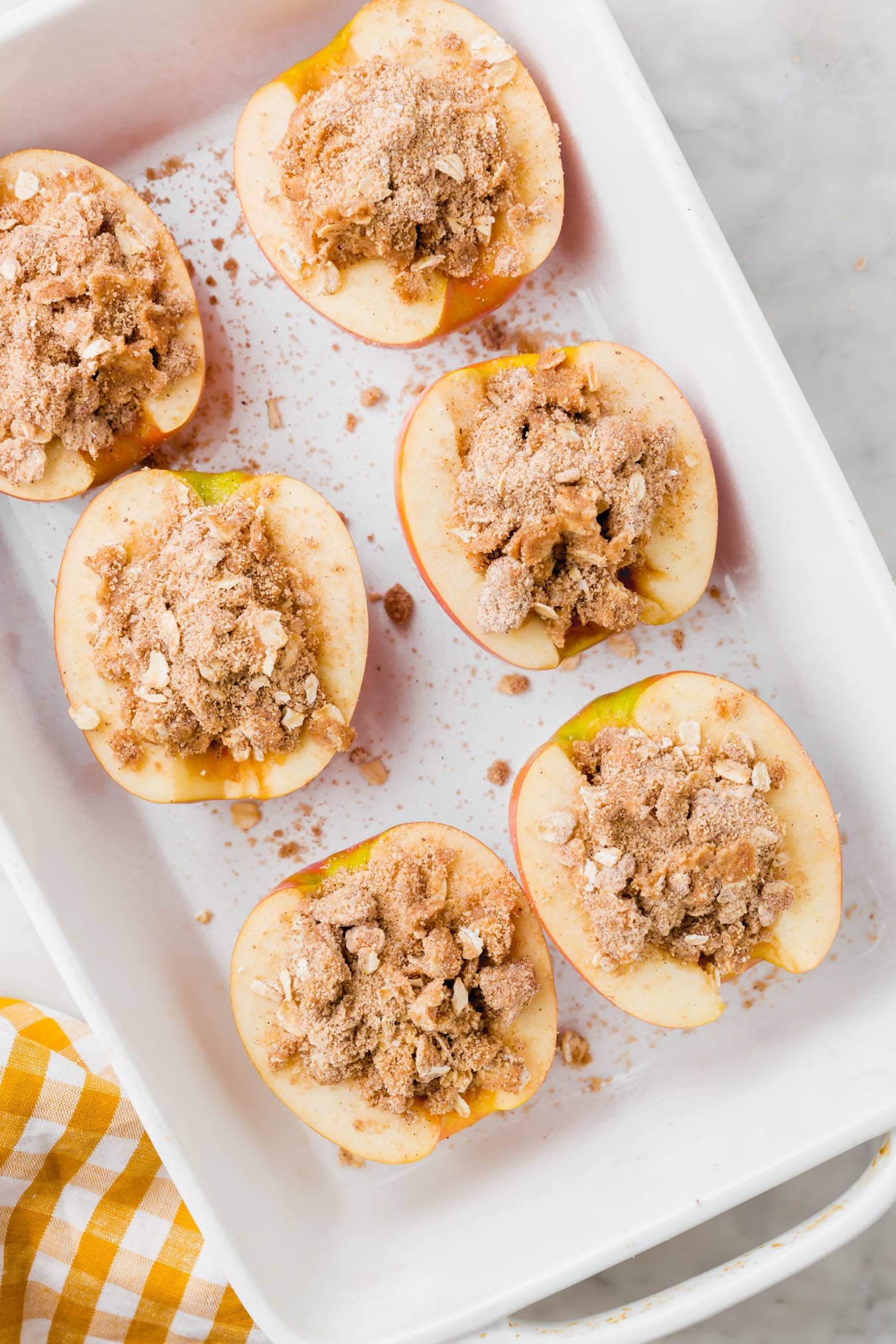 An overhead photo of apple halves stuffed with gluten-free streusel.
