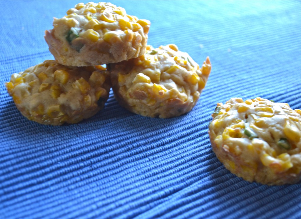 A stack of baked corn fritters on a blue placemat.