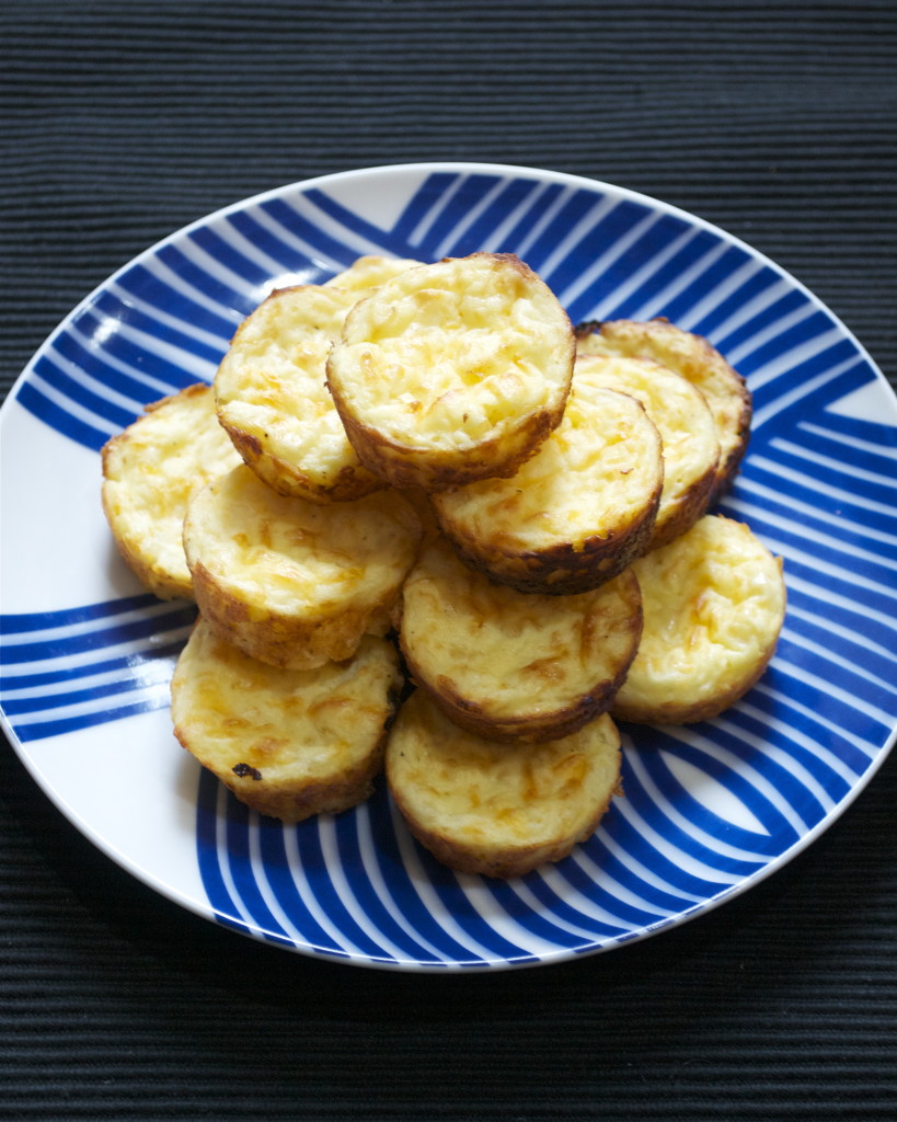 A pile of mini gluten-free quiches on a blue and white plate.