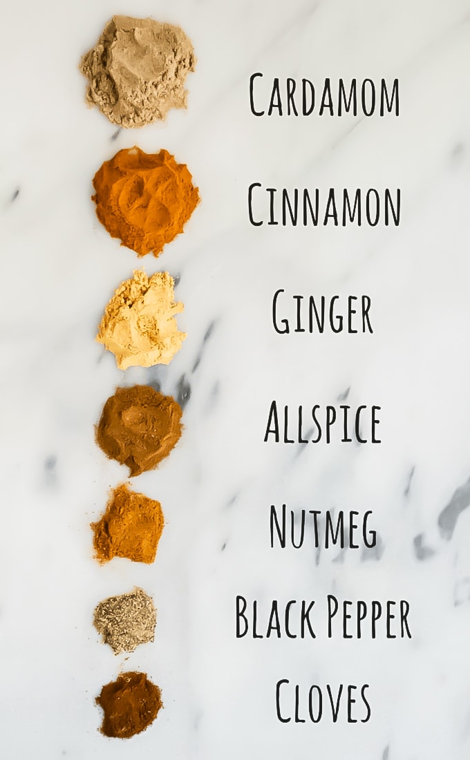 A photo showing spices on a marble table to make chai spice mix.