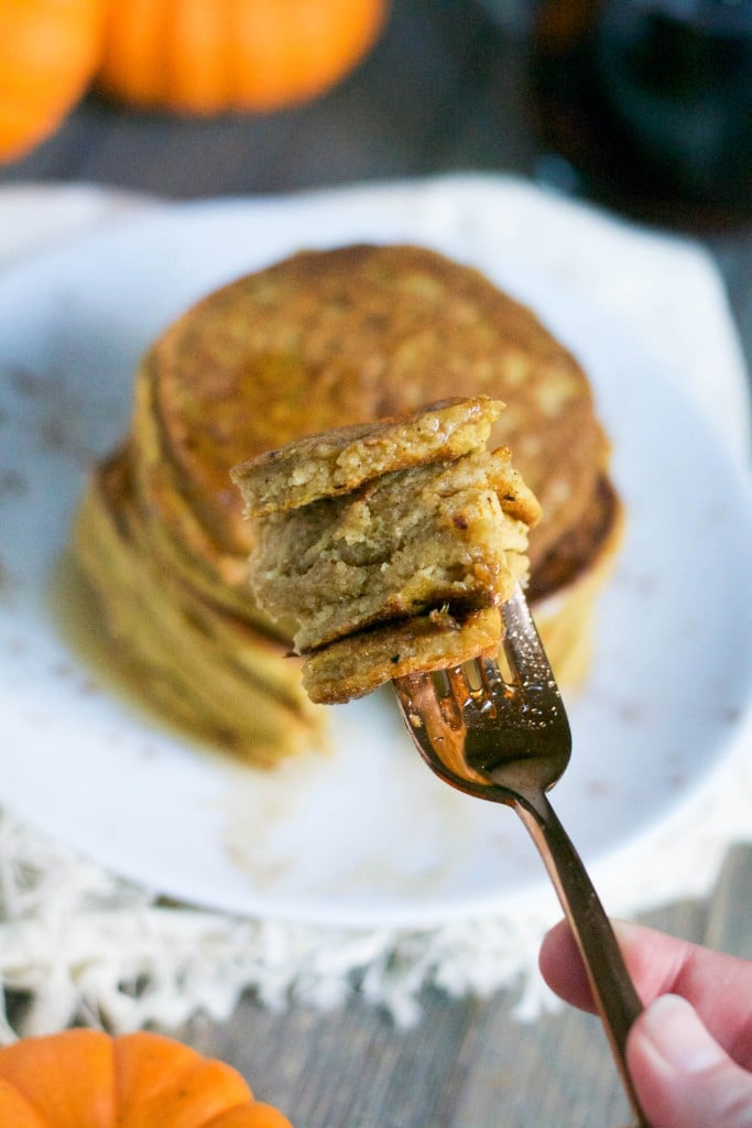 A fork with a big piece of pumpkin pancakes on it.
