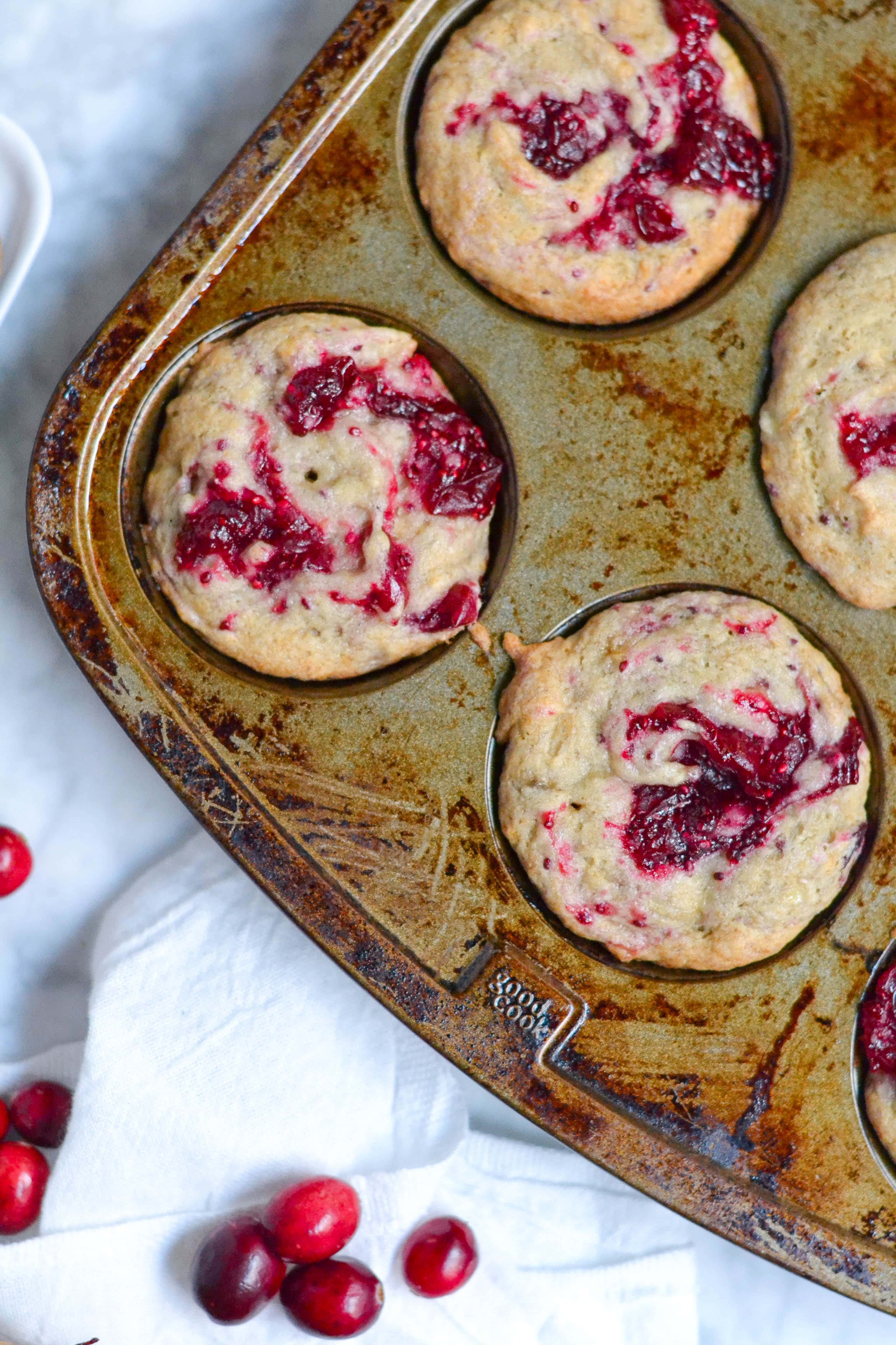 Baked banana cranberry muffins in a muffin tin.