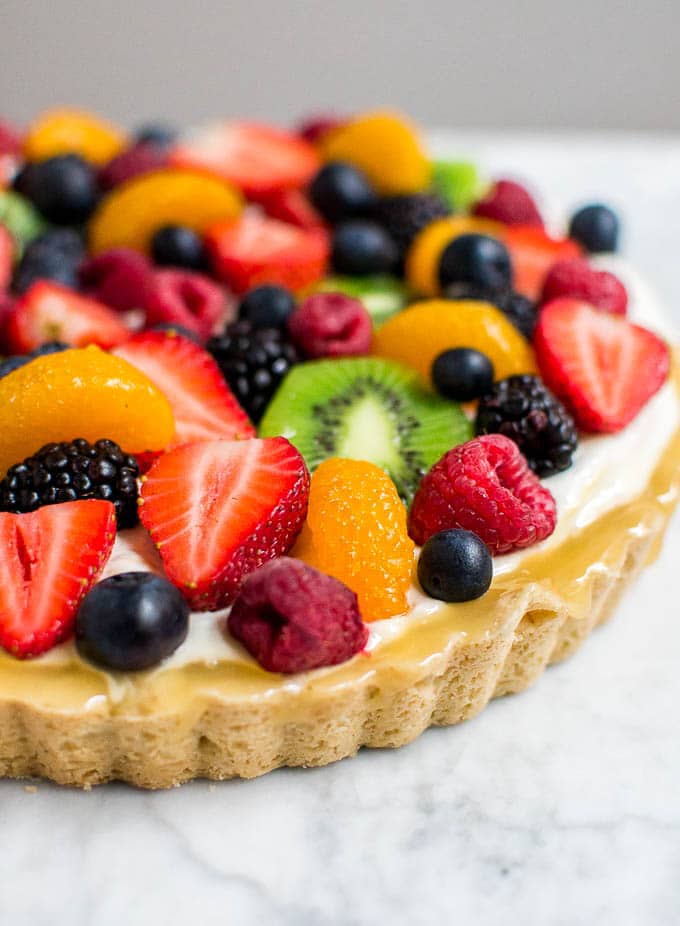 A photo of a gluten-free tart shell filled with lemon curd and fresh fruit.