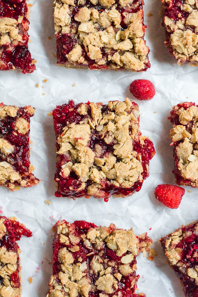Aerial view of nine gluten-free, dairy-free, vegan raspberry crumb bars on a table.