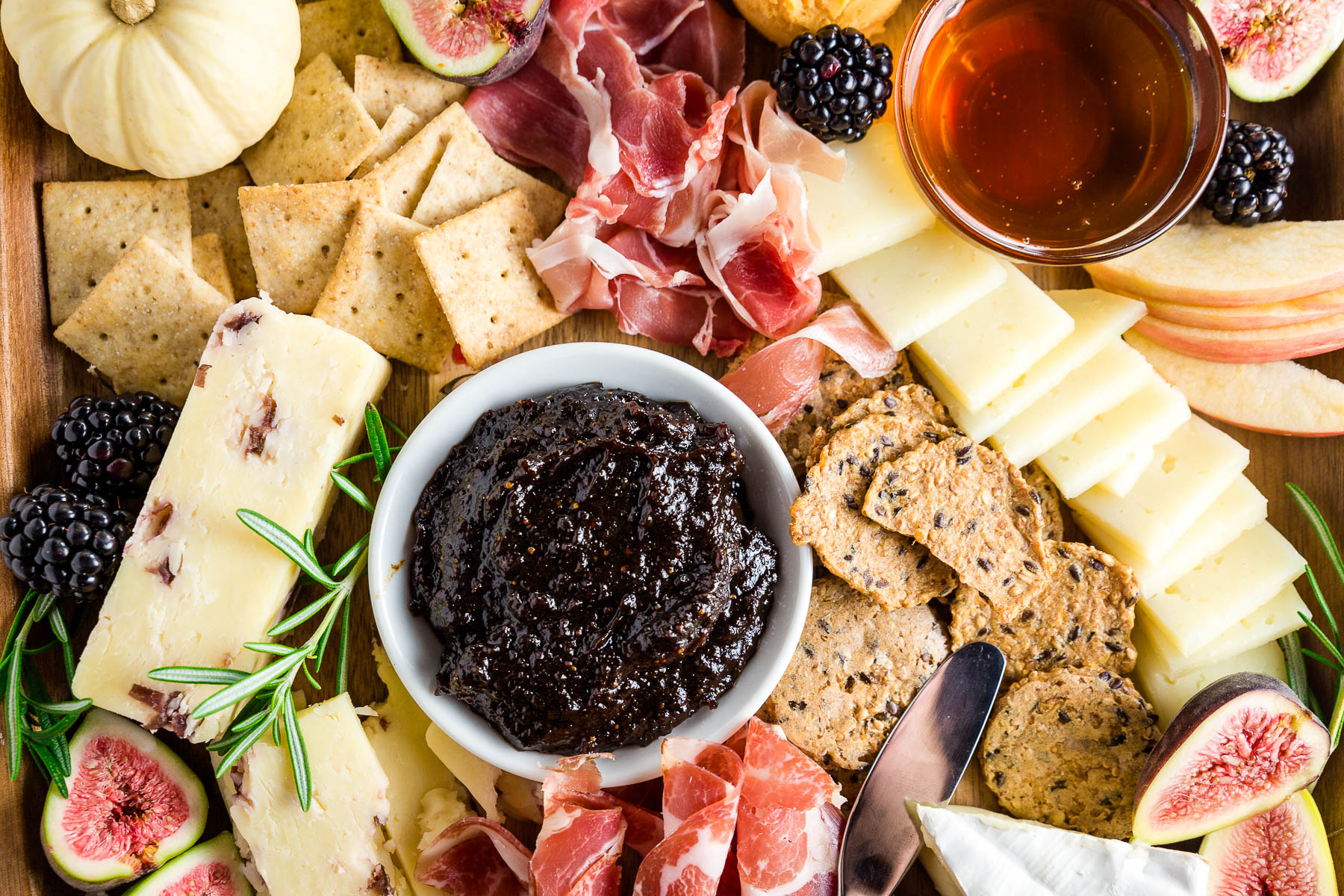 Orange fig jam with cheeses, meats and gluten-free crackers for a fall harvest charcuterie and cheese board
