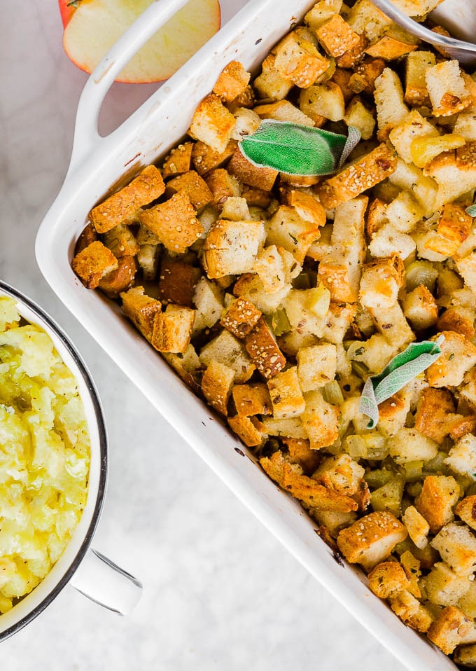 A baking dish with easy gluten-free stuffing topped with fresh sage.