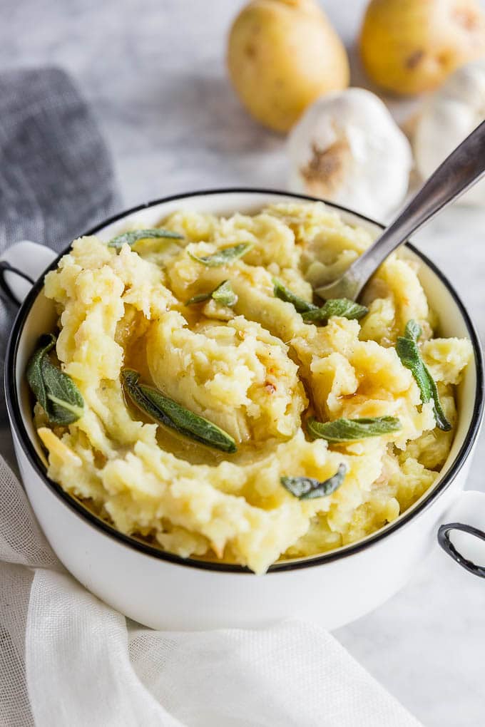 A bowl of easy roasted garlic mashed potatoes with brown butter and sage.