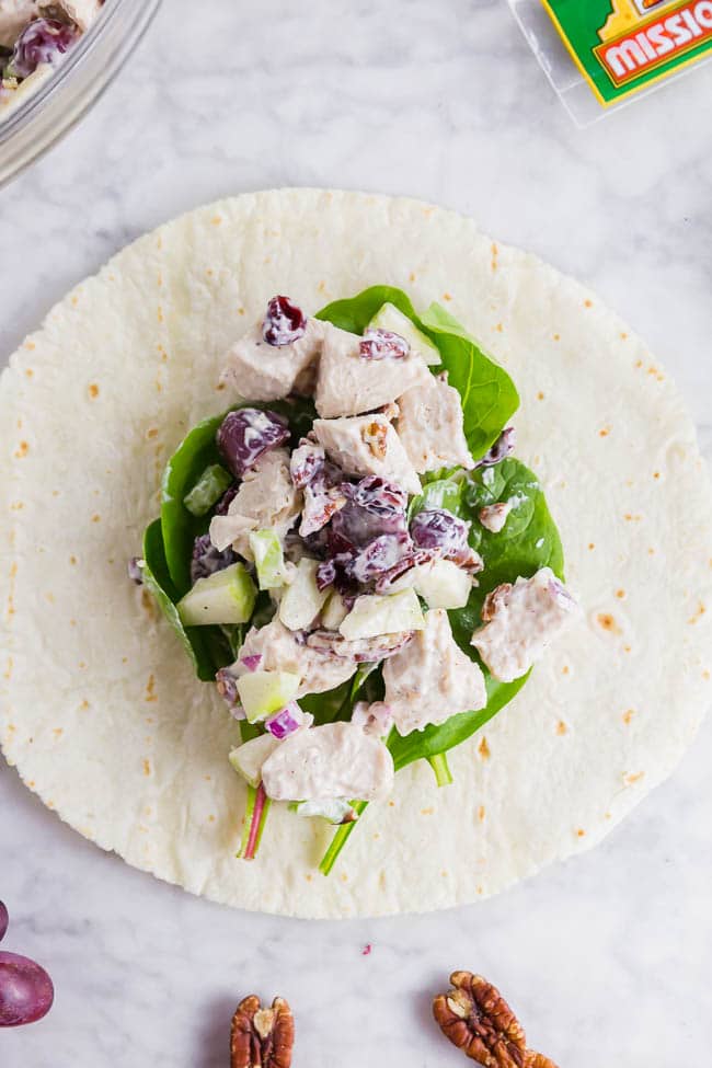 A photo of a Mission Gluten Free Tortilla on a table topped with gluten free chicken salad ready to roll up into a wrap.