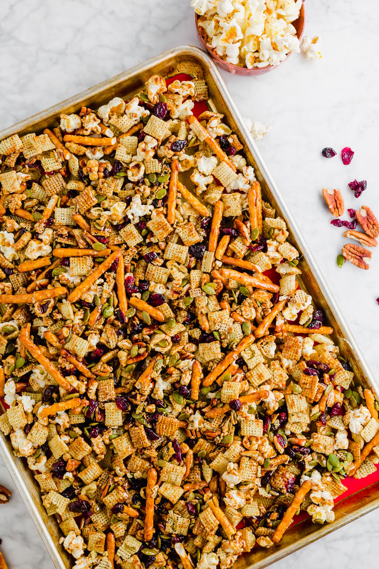 A photo of a sheet pan with gluten-free Maple Cayenne Chex Party Mix on it ready to be put in the oven.