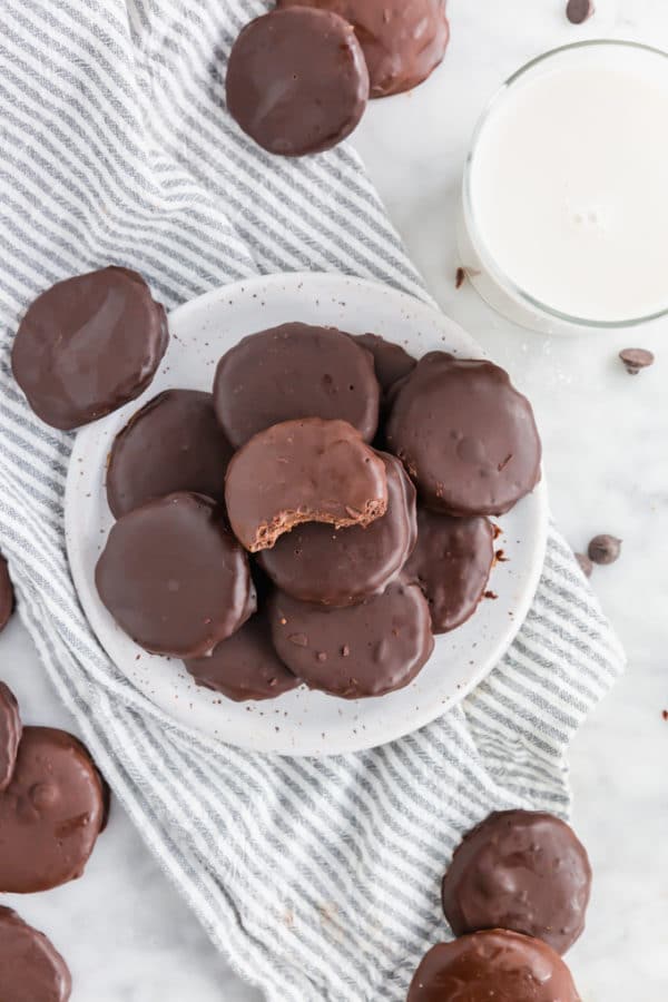 A plate of gluten-free chocolate mint cookies with a glass of milk.