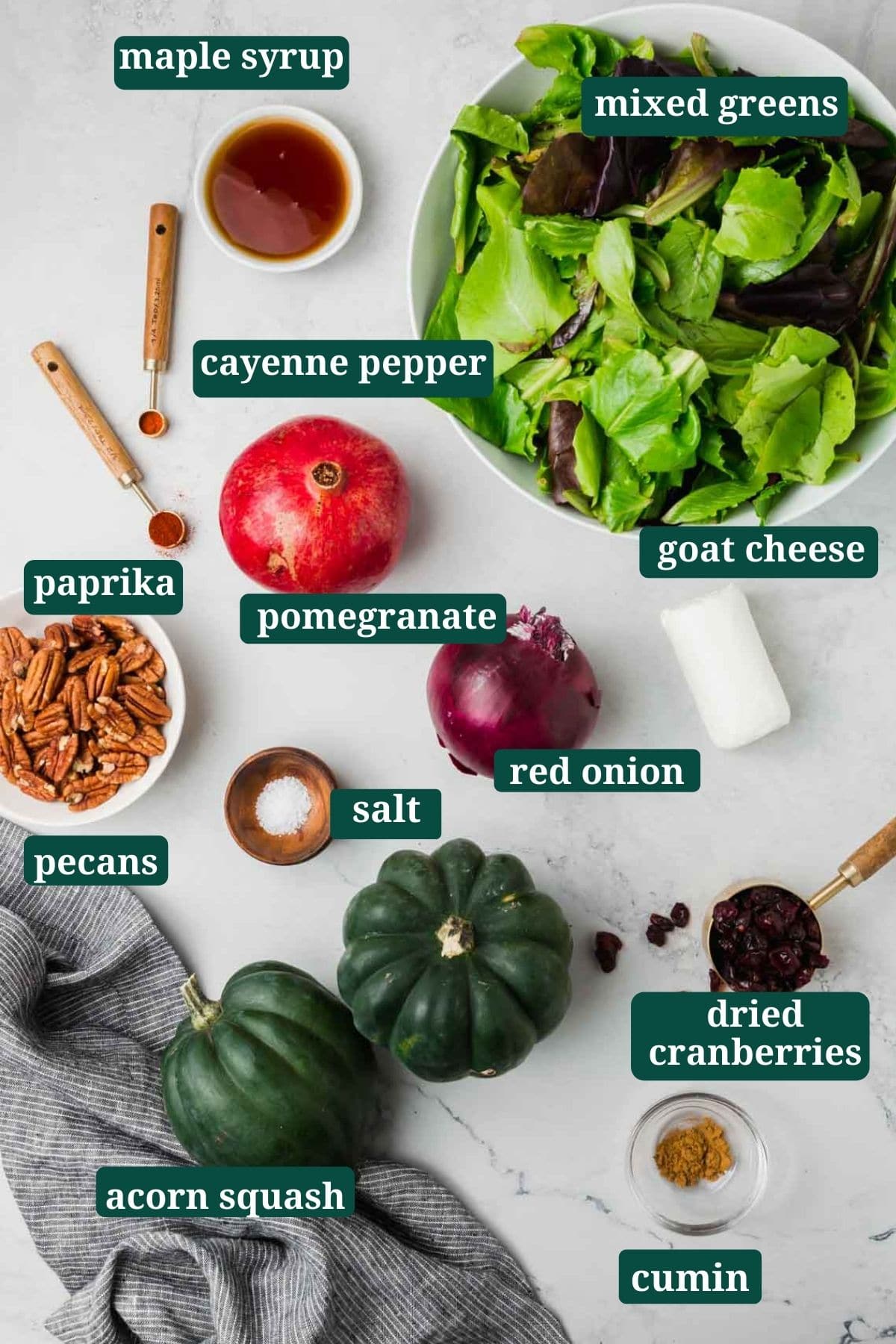 Pomegranate, mixed greens, acorn squash, pecans, goat cheese, red onion, and spices to make a salad.