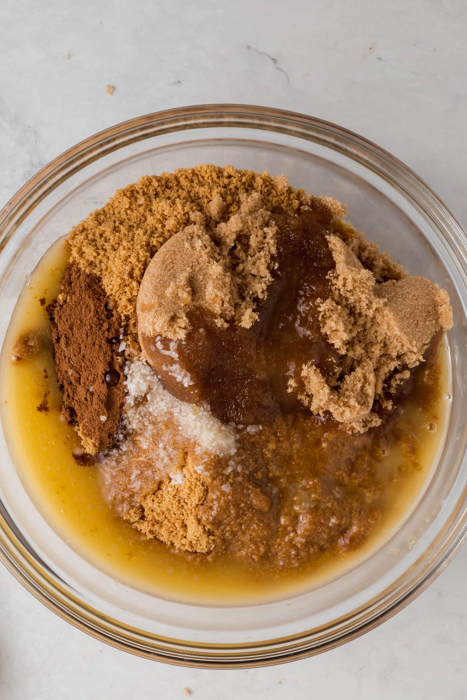 A bowl of gluten-free graham cracker crumbs, brown sugar, cinnamon, salt, and melted butter.