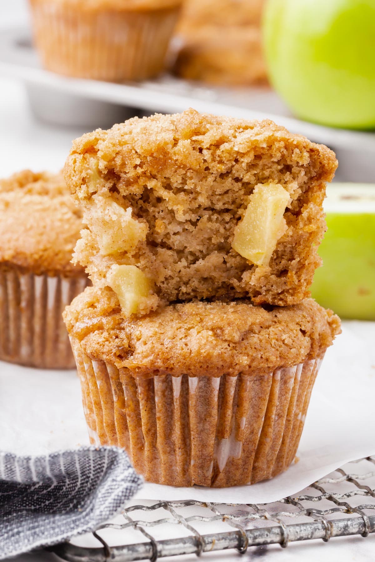 Close up of two gluten-free vegan apple cinnamon stacked on one another, the top one bitten into.
