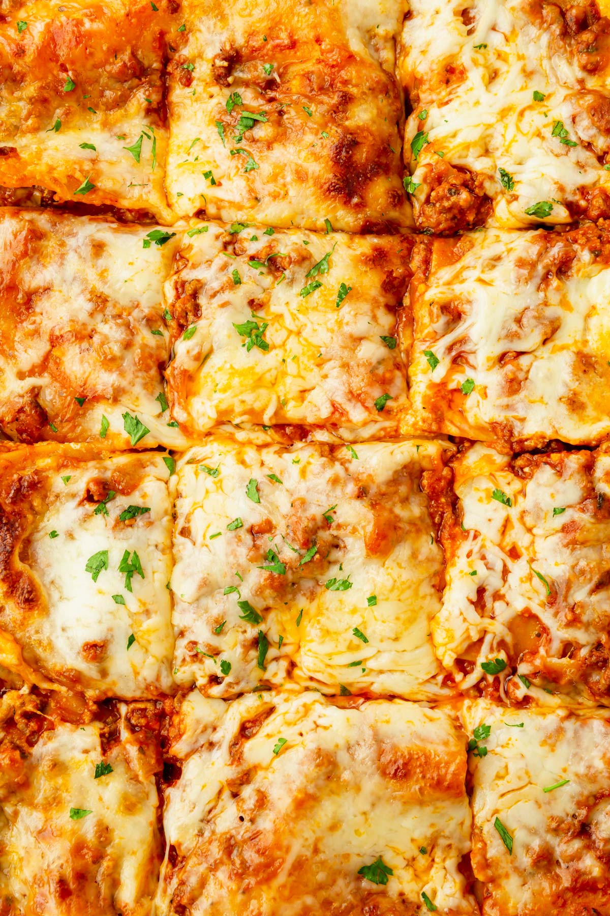 A dish of gluten-free beef lasagna cut into squares.