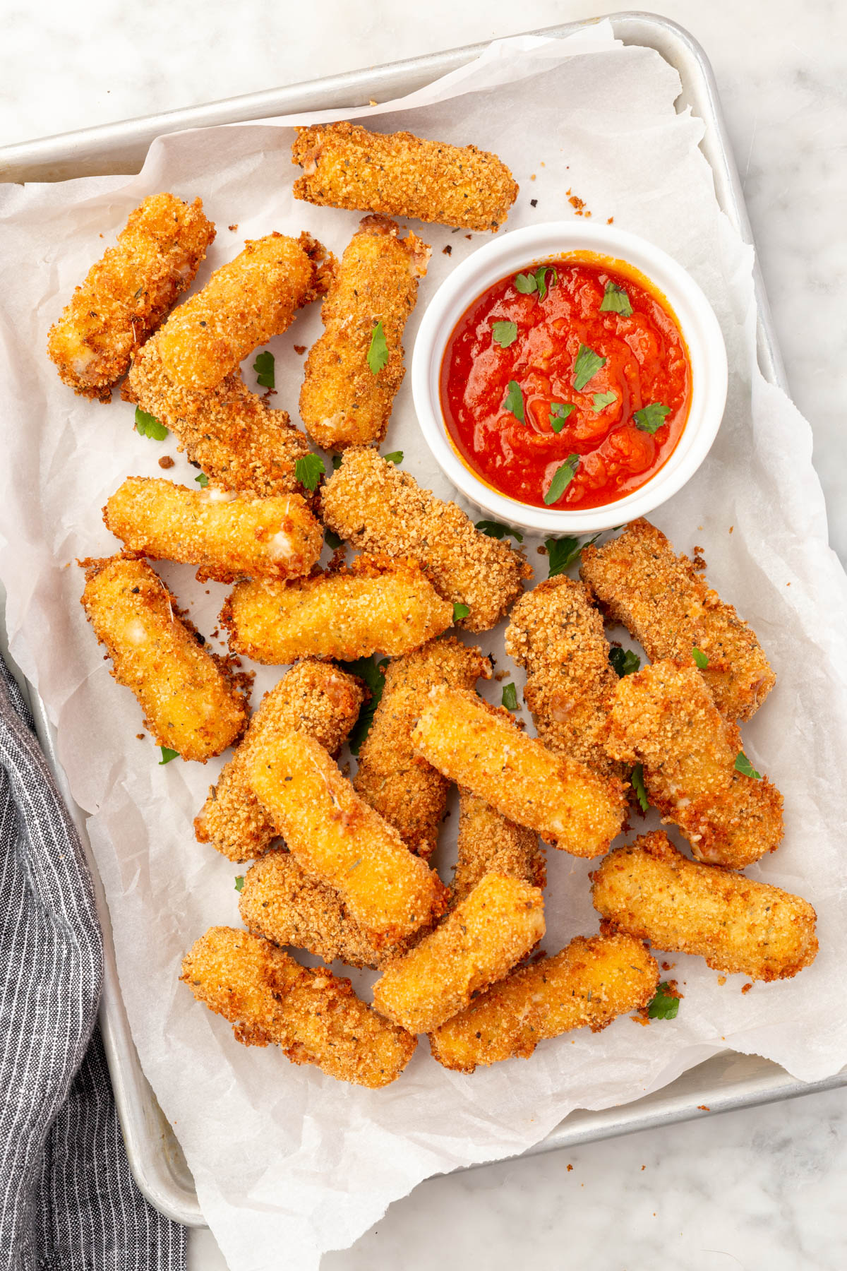 A plate of gluten-free mozzarella sticks and a side of marinara sauce.