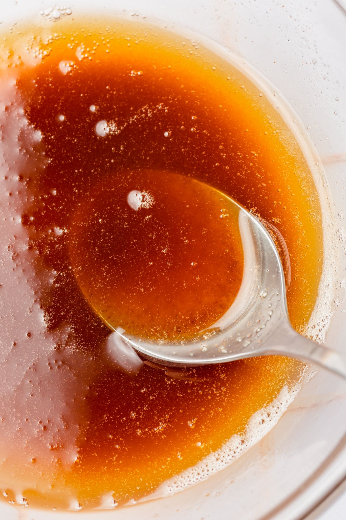 A close up brown butter being spooned from a bowl.