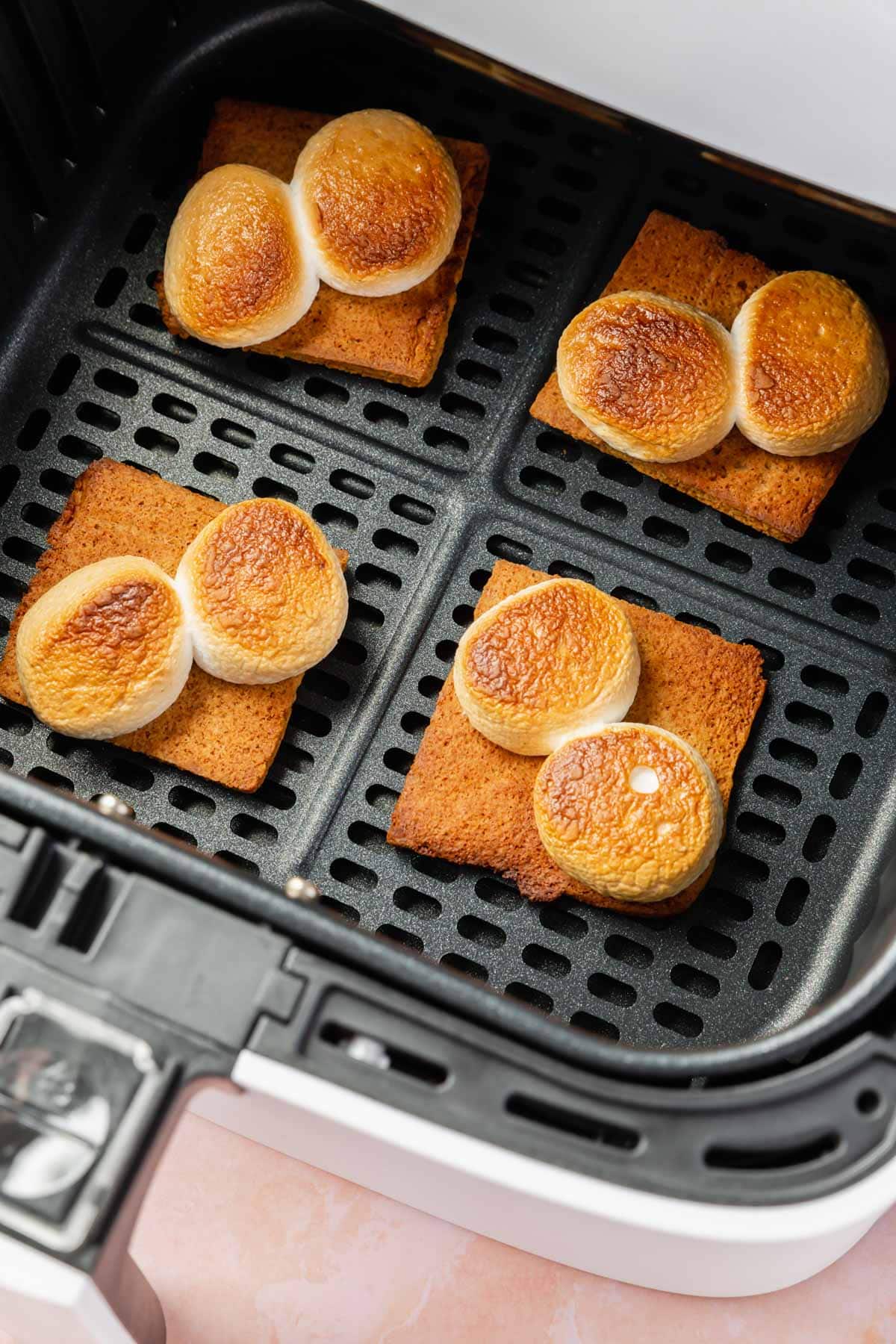 Toasted marshmallows on top of graham crackers in an air fryer.