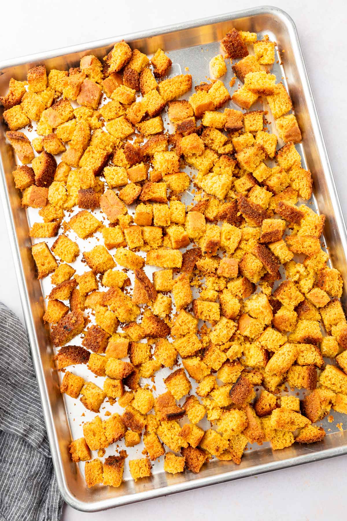 A baking sheet with toasted gluten-free cornbread cubes on it.