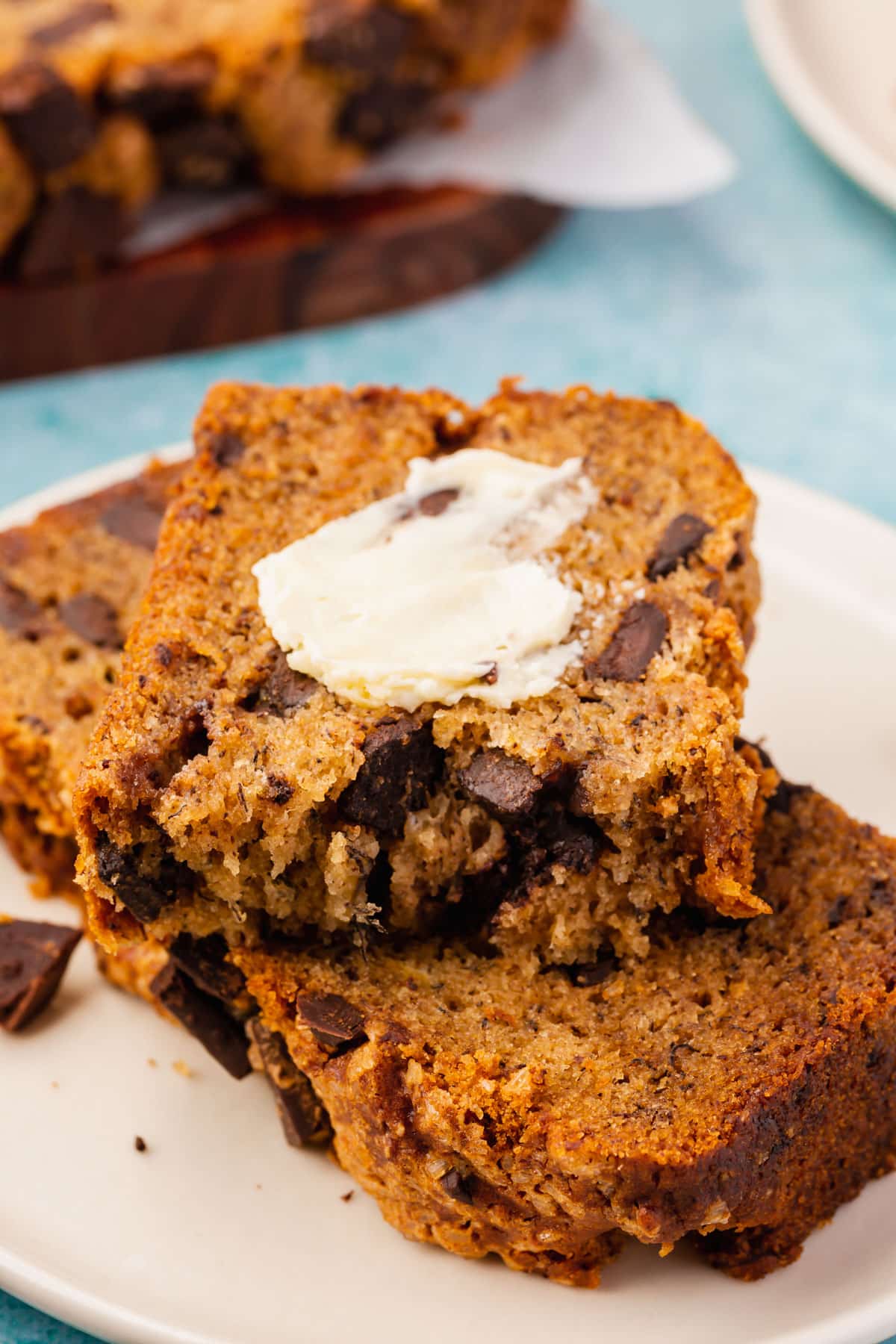 Two slices of gluten-free banana bread slathered with vegan butter.