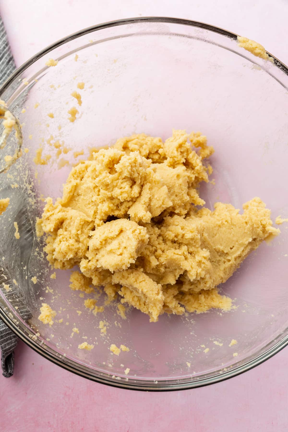 A glass mixing bowl with a creamed butter and sugar in it.