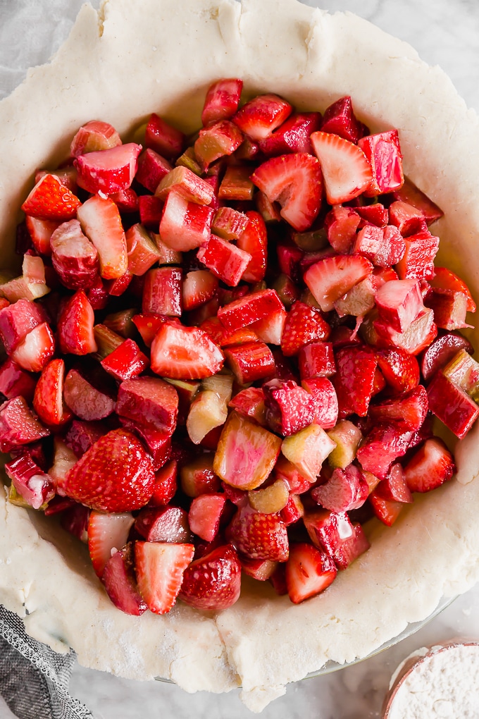 Strawberry rhubarb pie filling that has been spooned into a gluten-free pie crust before baking.