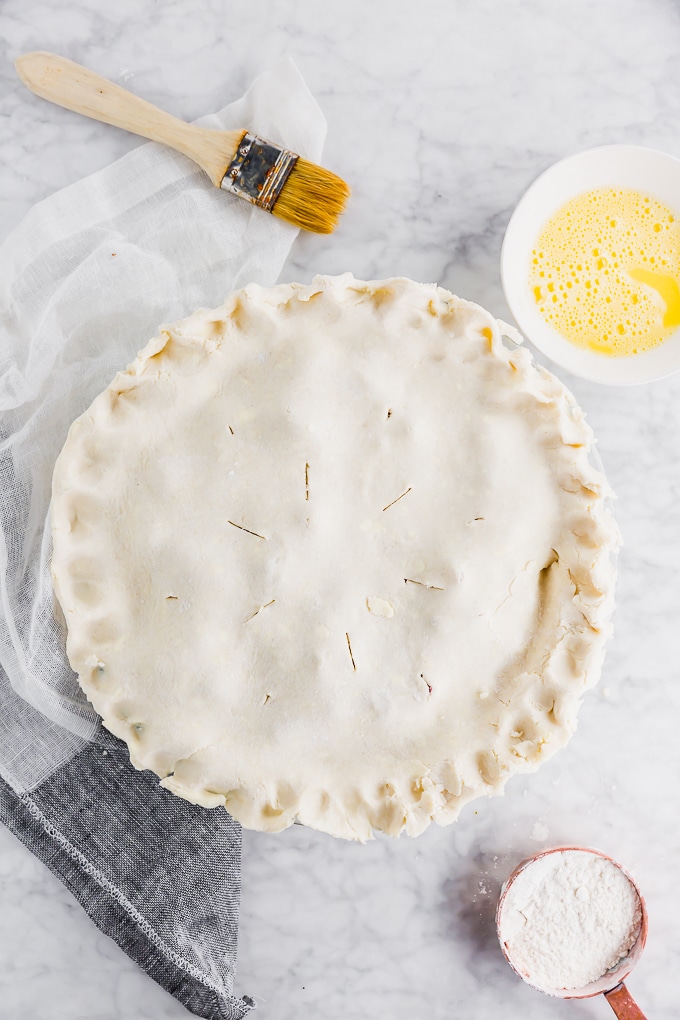 A gluten-free pie with crimped edges before baking in the oven.