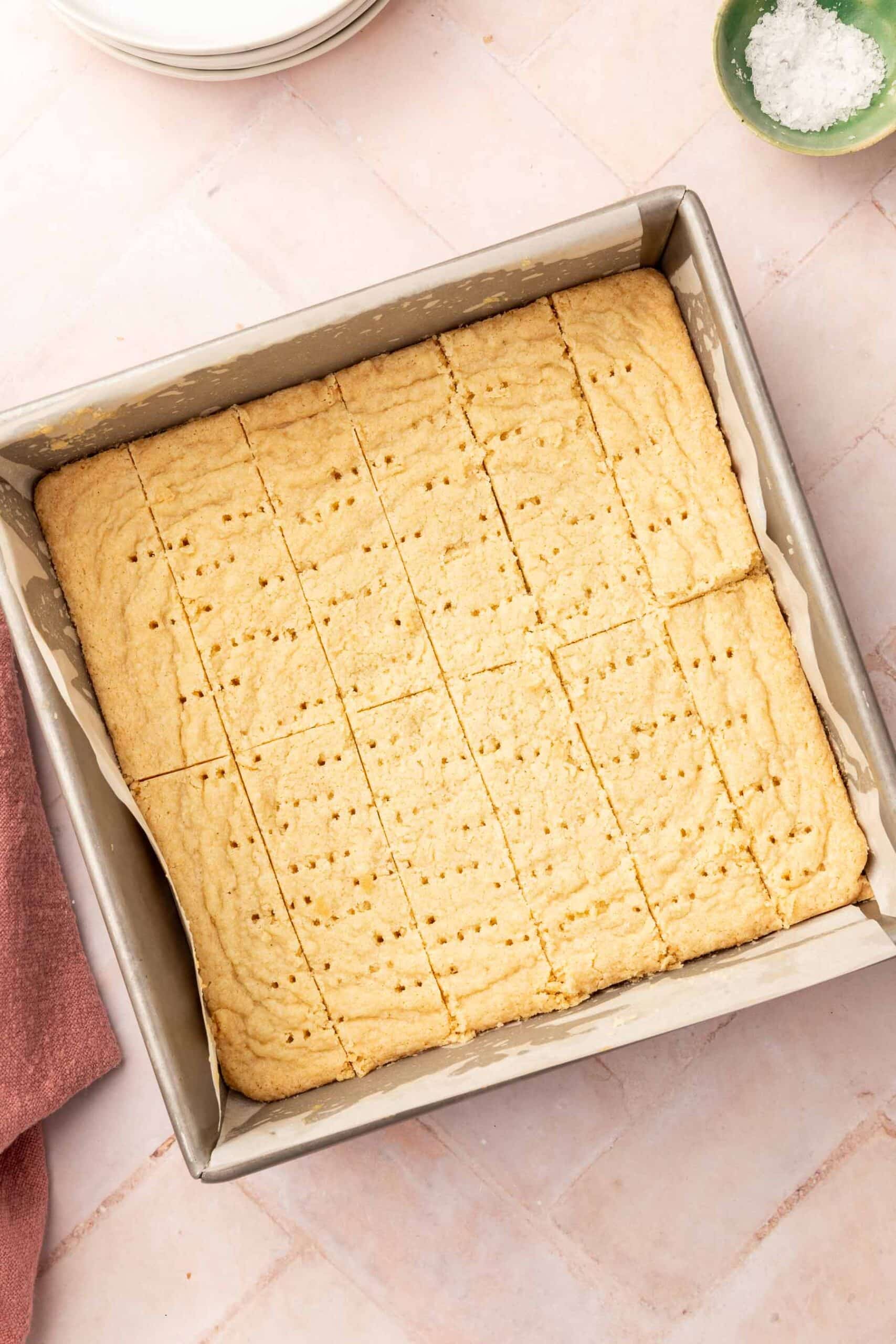 A square baking pan filled with slices of gluten-free shortbread after baking in the oven.