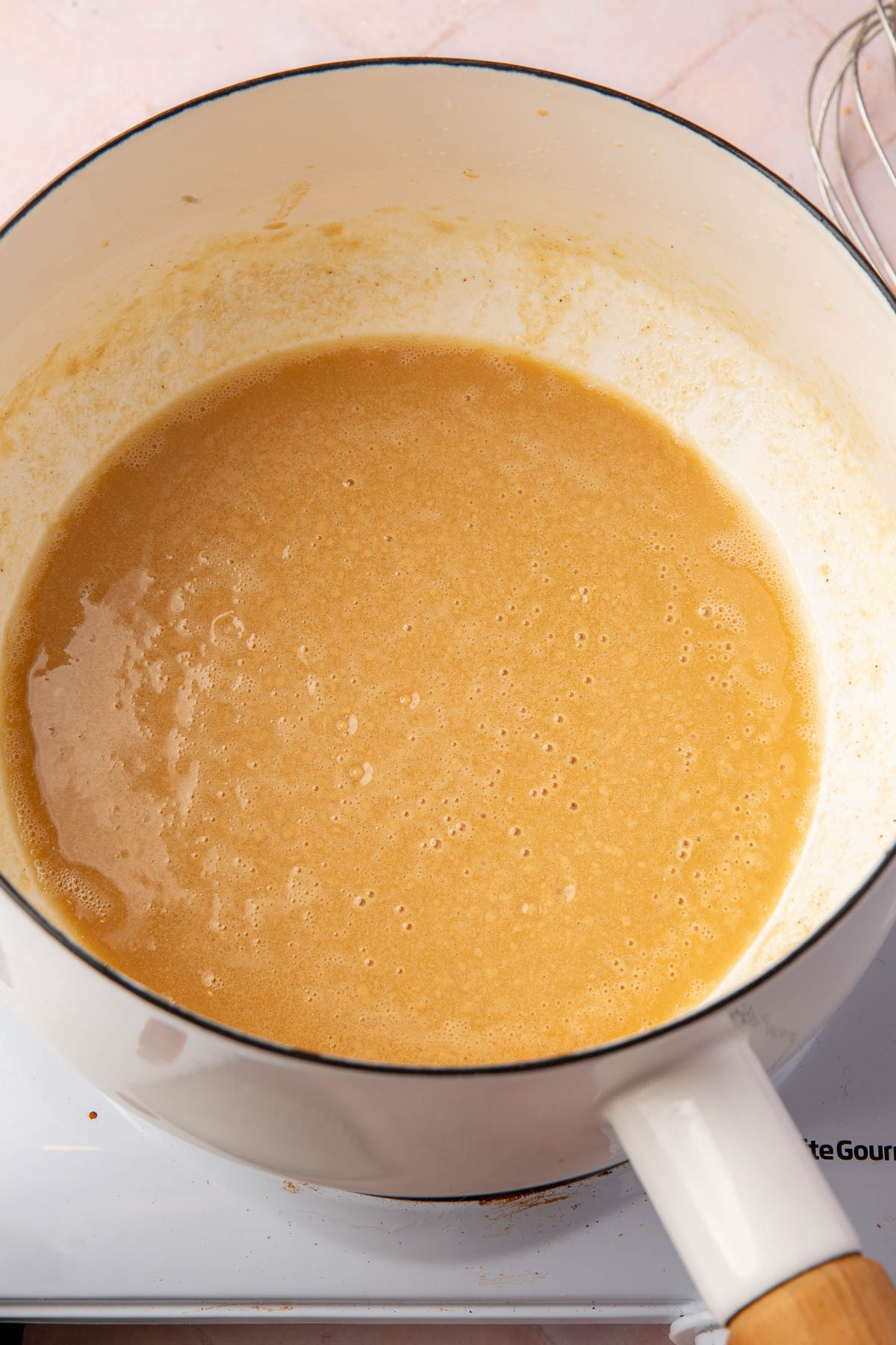 A golden brown gluten-free roux in a white saucepan.