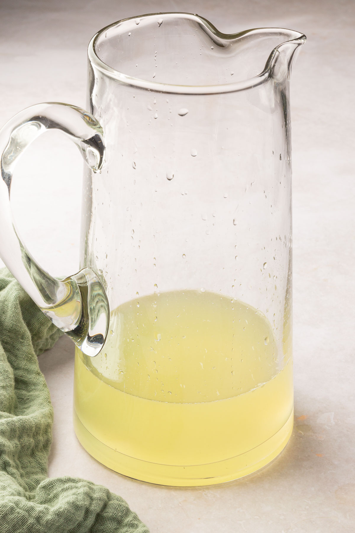 A glass pitcher of lemonade concentrate before adding additional water.