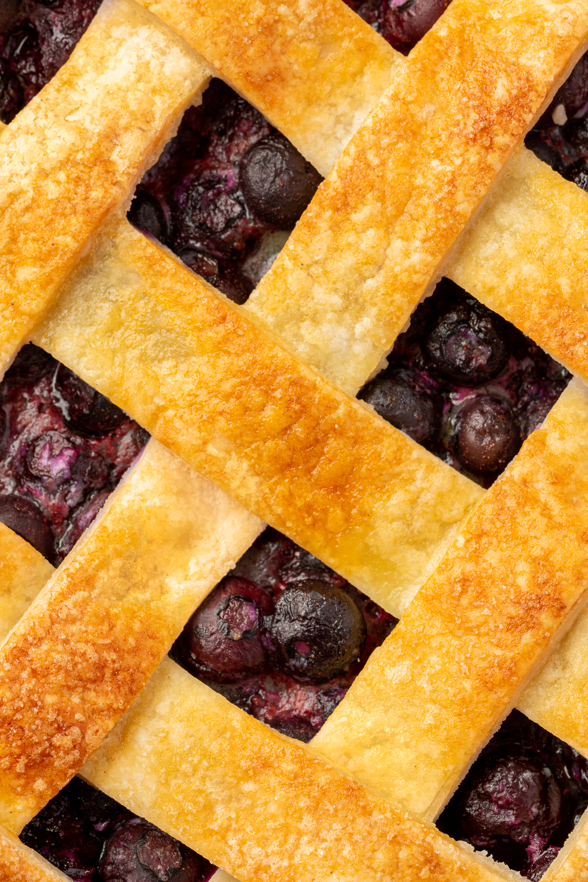 Close-up of the golden lattice crust on a gluten-free blueberry pie, highlighting the flaky, buttery texture of the pie dough.