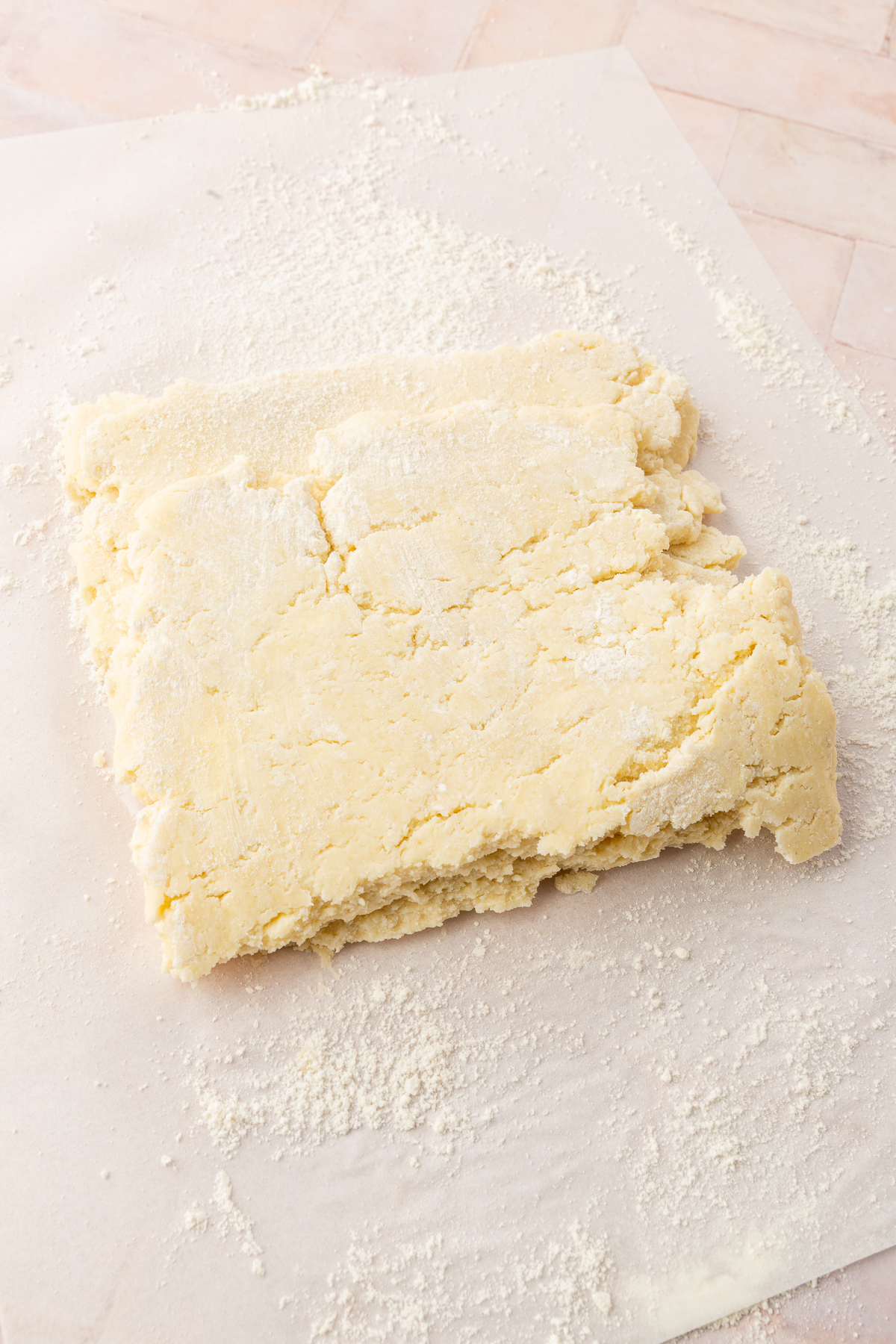 A close up of a large rectangle of gluten-free pie dough that has been folded in a letter fold to create three layers of dough.