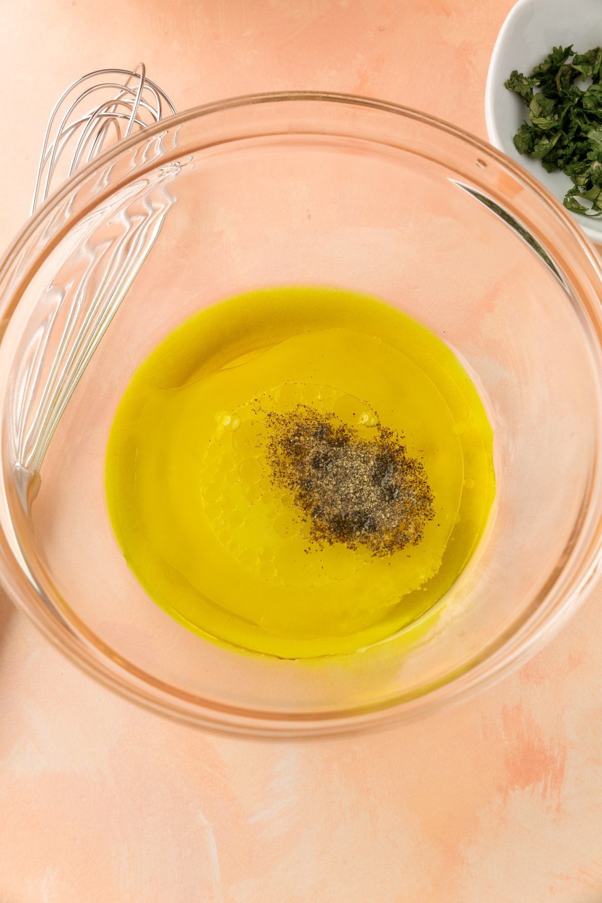 Olive oil, lemon juice, salt and pepper in small mixing bowl not yet mixed.