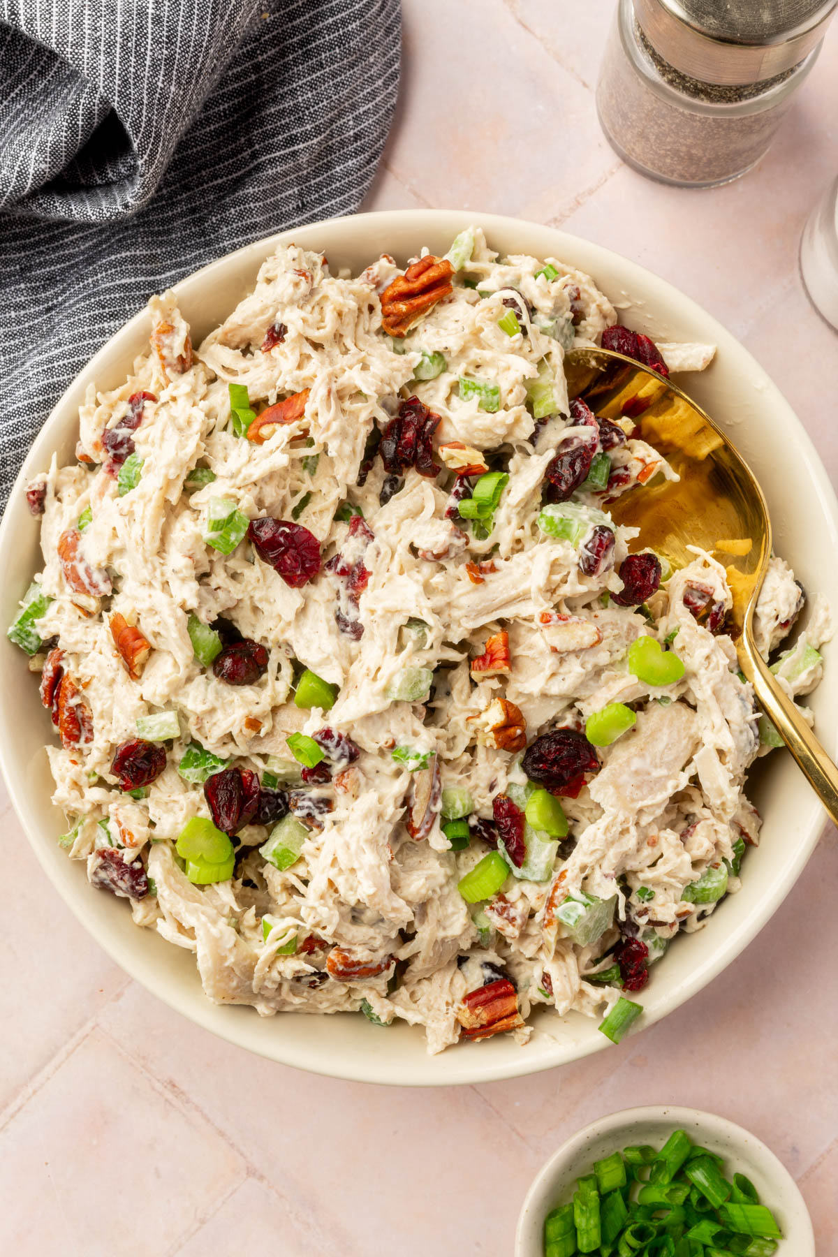 Cranberry pecan chicken salad in large serving bowl on a brick countertop.