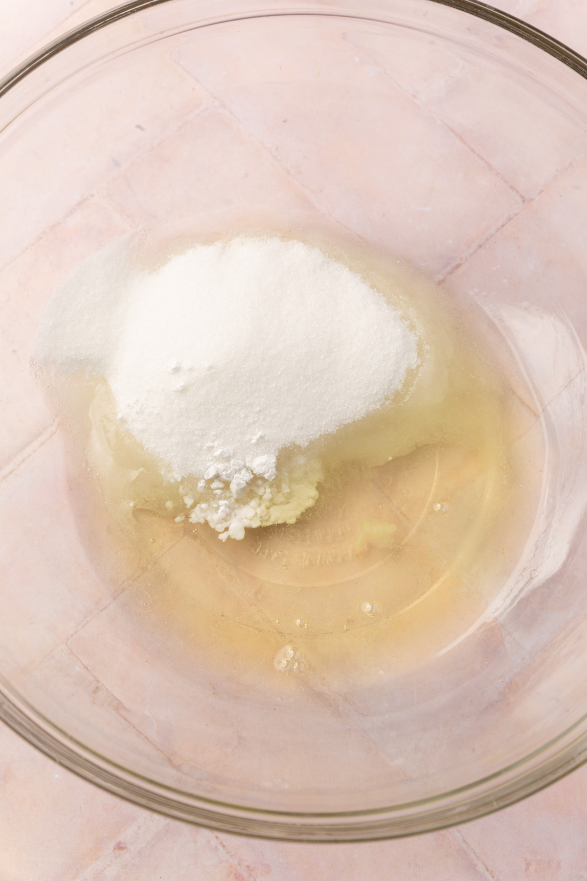 A bowl with granulated sugar, cream of tartar and egg whites to before mixing together.