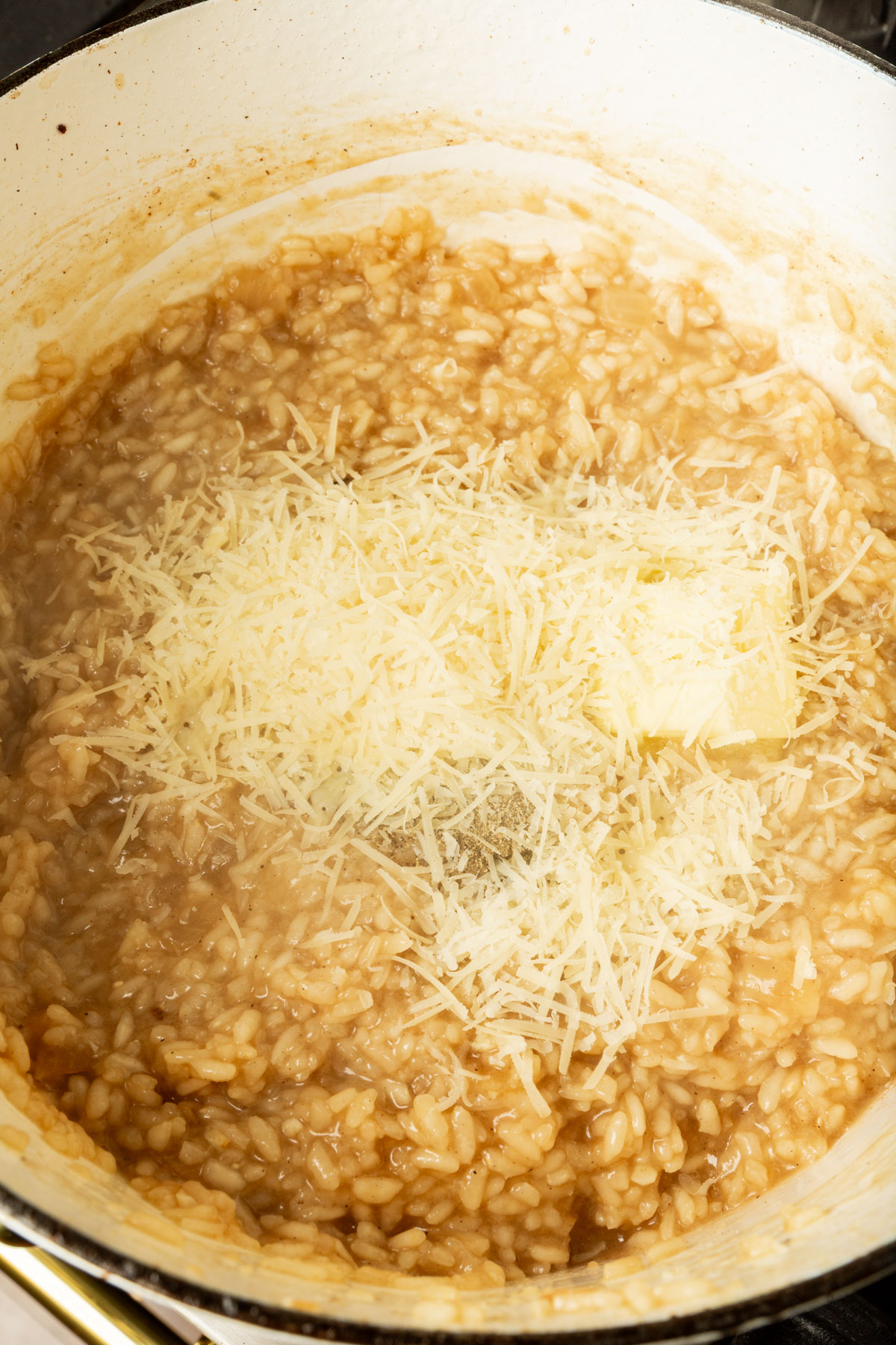 Arborio rice, butter, parmesan cheese, vegetable broth mixed together in a large pot.