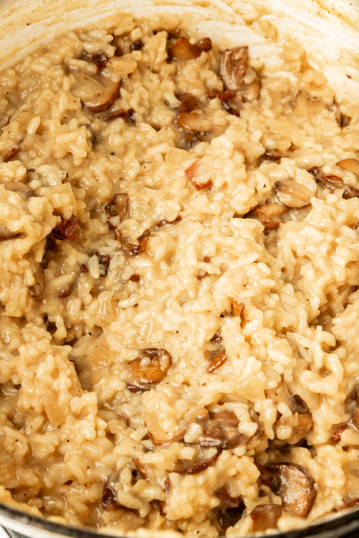 Close up image of mixed up bacon mushroom risotto.