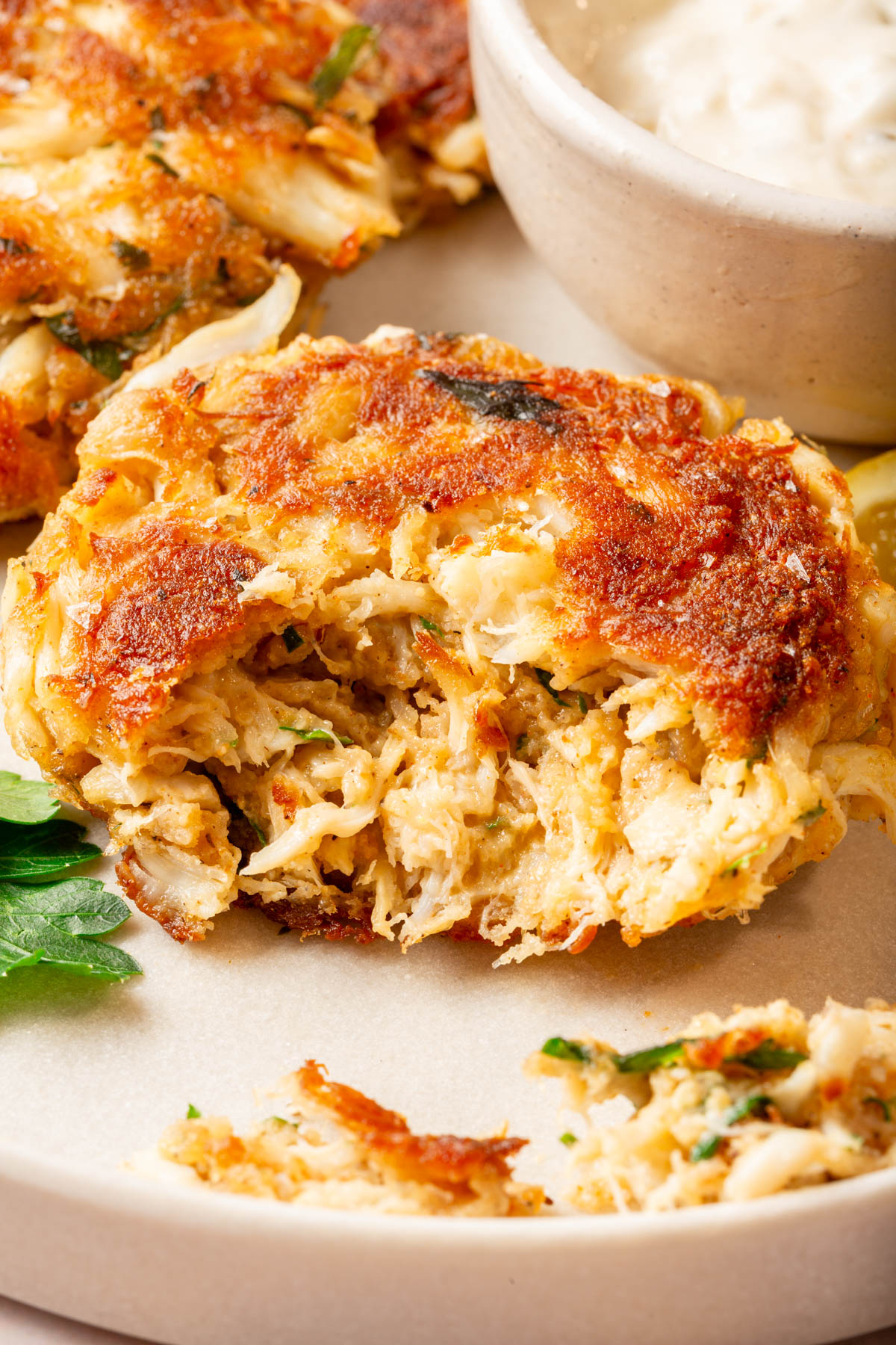 Close-up of a flaky gluten-free crab cake showing tender inside and golden edges.