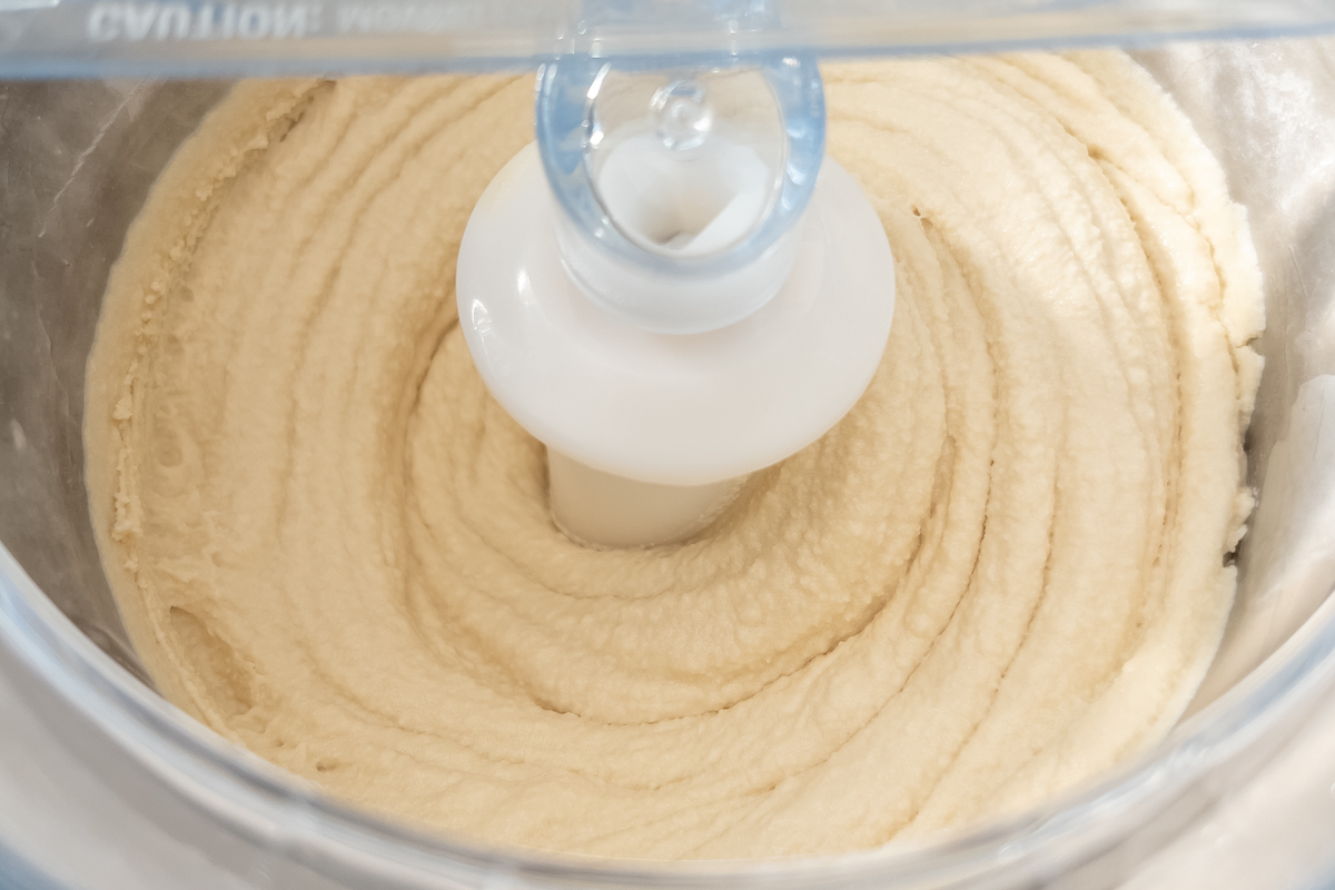 Espresso custard mixture being churned into ice cream in an electric ice cream maker.