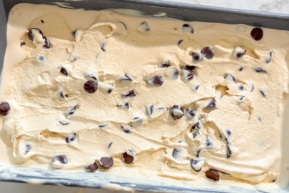 Freshly churned espresso chocolate chip ice cream in a metal loaf pan, ready to be frozen.