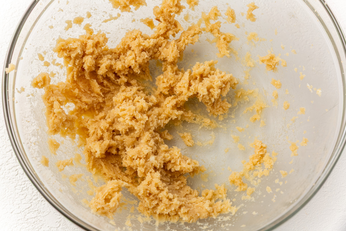 Butter and sugars creamed together in a glass bowl until light and fluffy for gluten-free pumpkin coffee cake batter.