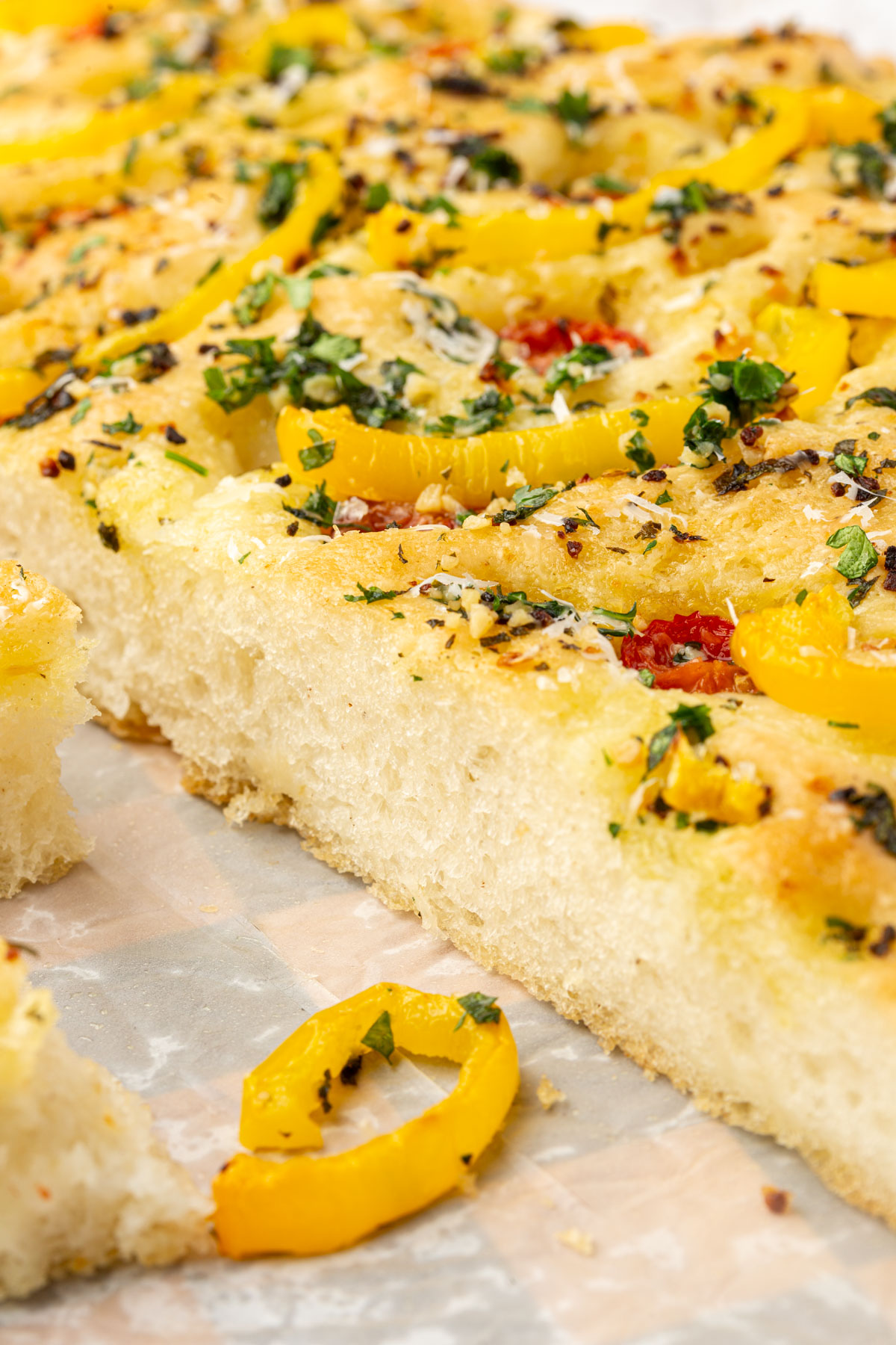 Extreme closeup of gluten-free Christmas tree focaccia showing soft airy crumb texture and slice with yellow pepper decoration.