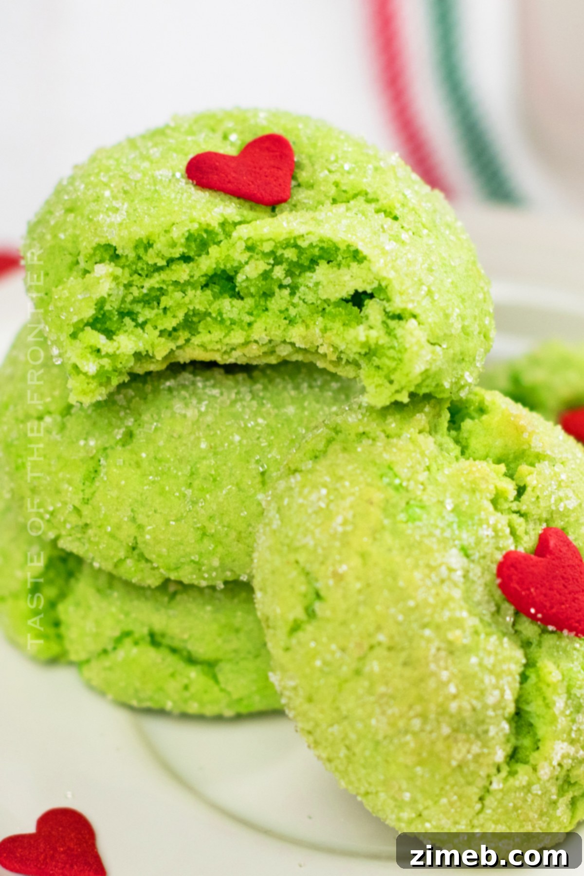 Grinch's Heart-Melting Crinkles 10 Grinch Christmas Cookies artfully arranged on a platter, showcasing their festive appeal and green color with red hearts.