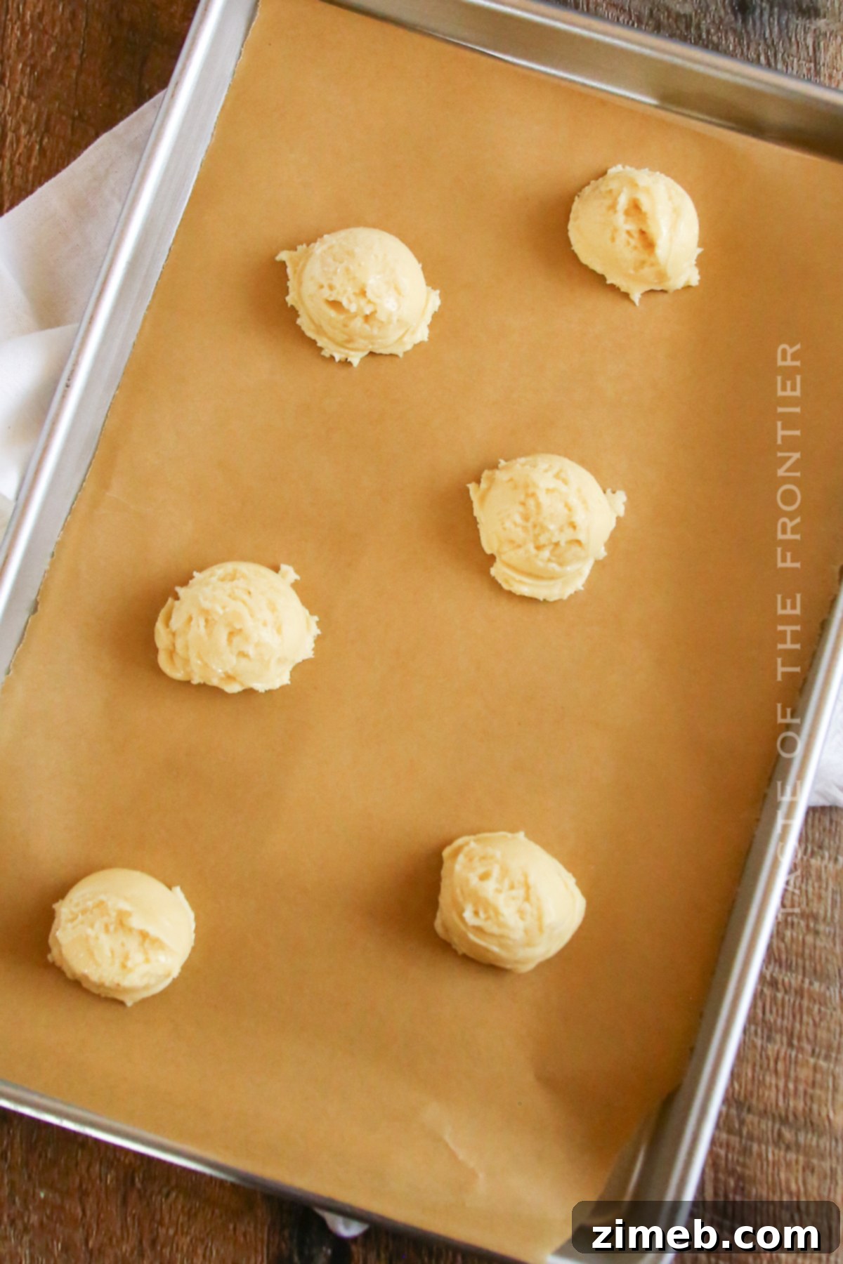 Festive Snowman Cookies 6 Cookie dough for snowman cake mix cookies being scooped onto a baking sheet.