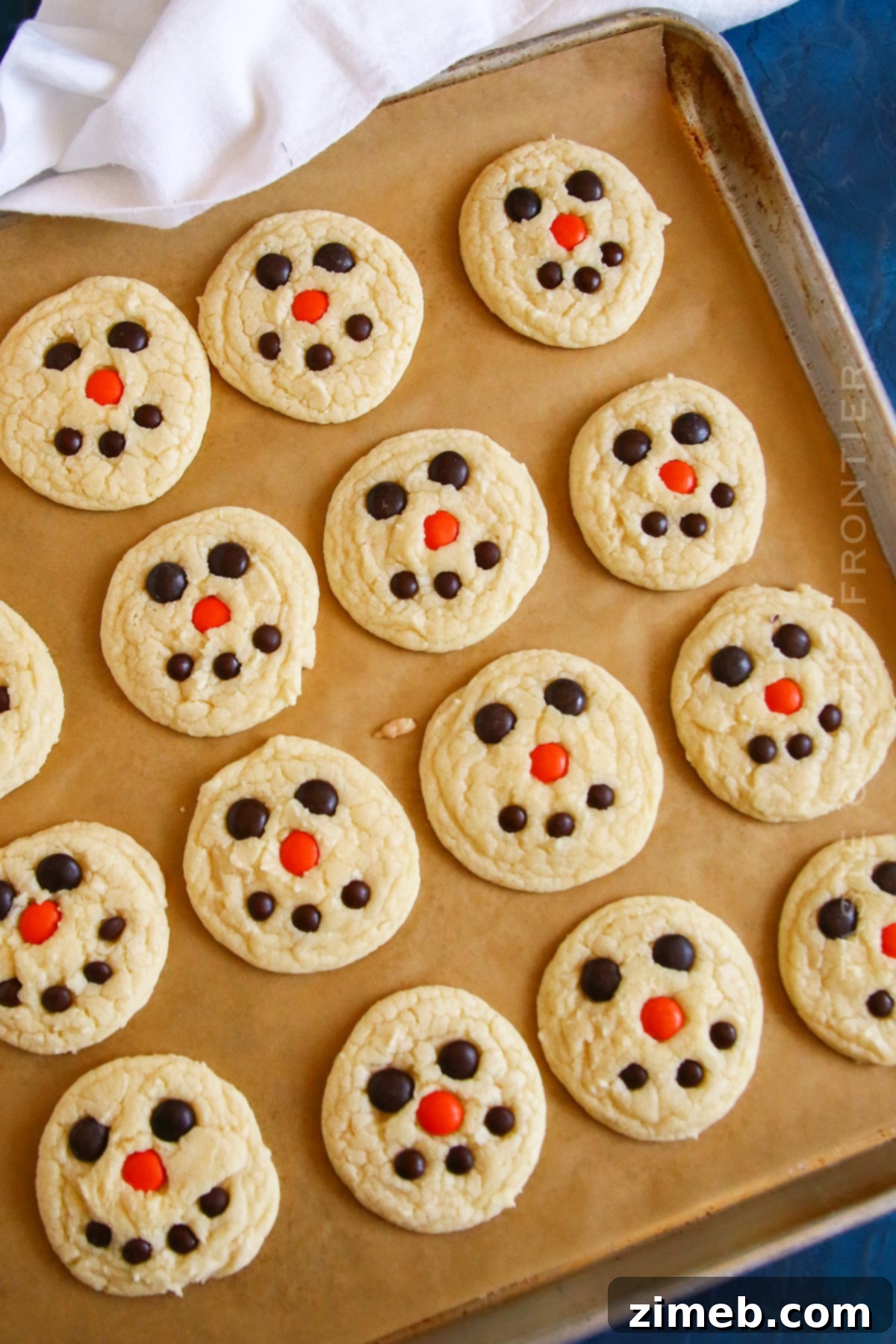 Festive Snowman Cookies 8 Freshly baked snowman cake mix cookies on a cooling rack.