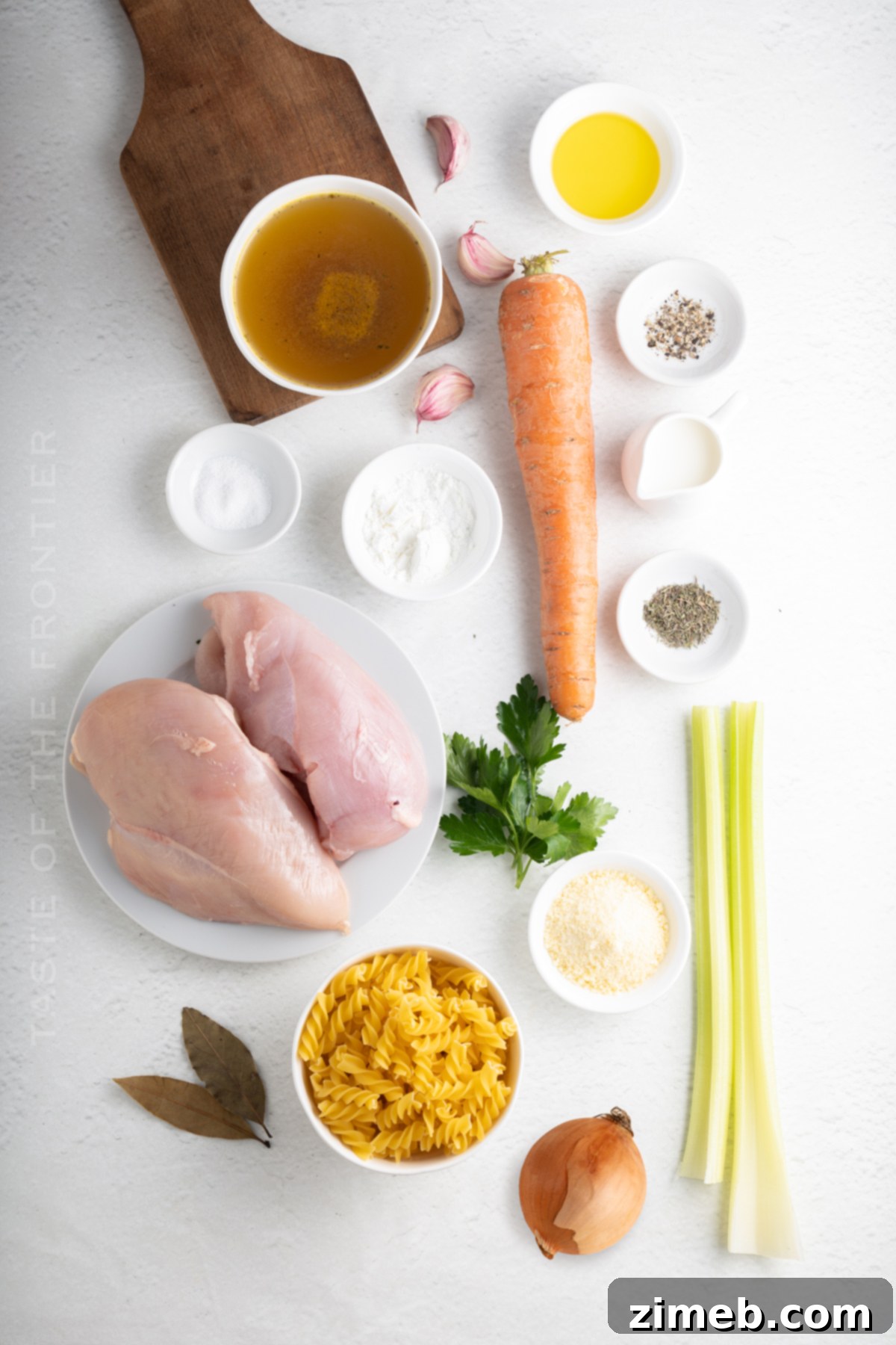 Hearty Chicken Noodle Comfort 4 Fresh ingredients laid out for an easy homemade chicken noodle soup recipe: carrots, celery, onion, garlic, chicken breast, and herbs.