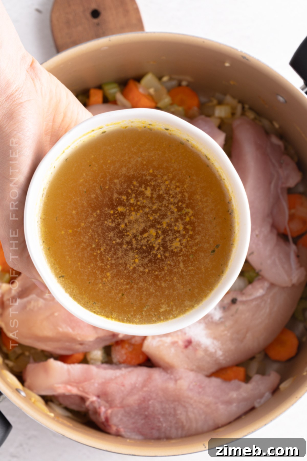 Hearty Chicken Noodle Comfort 7 Close-up of golden, rich chicken broth simmering in a pot, forming the base of a comforting chicken noodle soup.