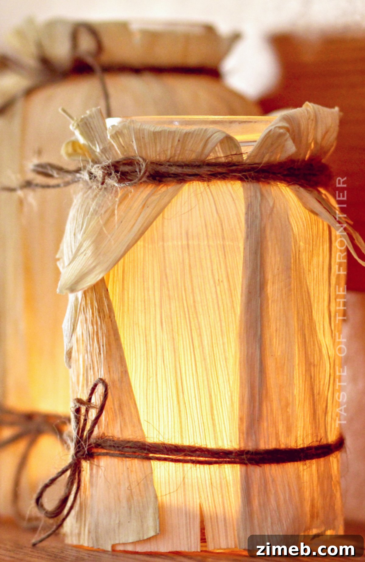 Candle glowing warmly inside a rustic corn husk luminary, perfect for fall evenings
