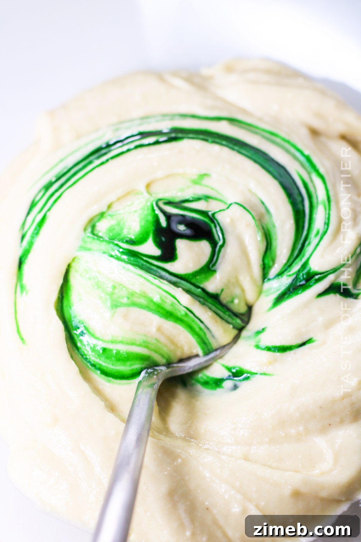 Adding green food coloring to cake batter for a St. Patrick's Day themed cake.