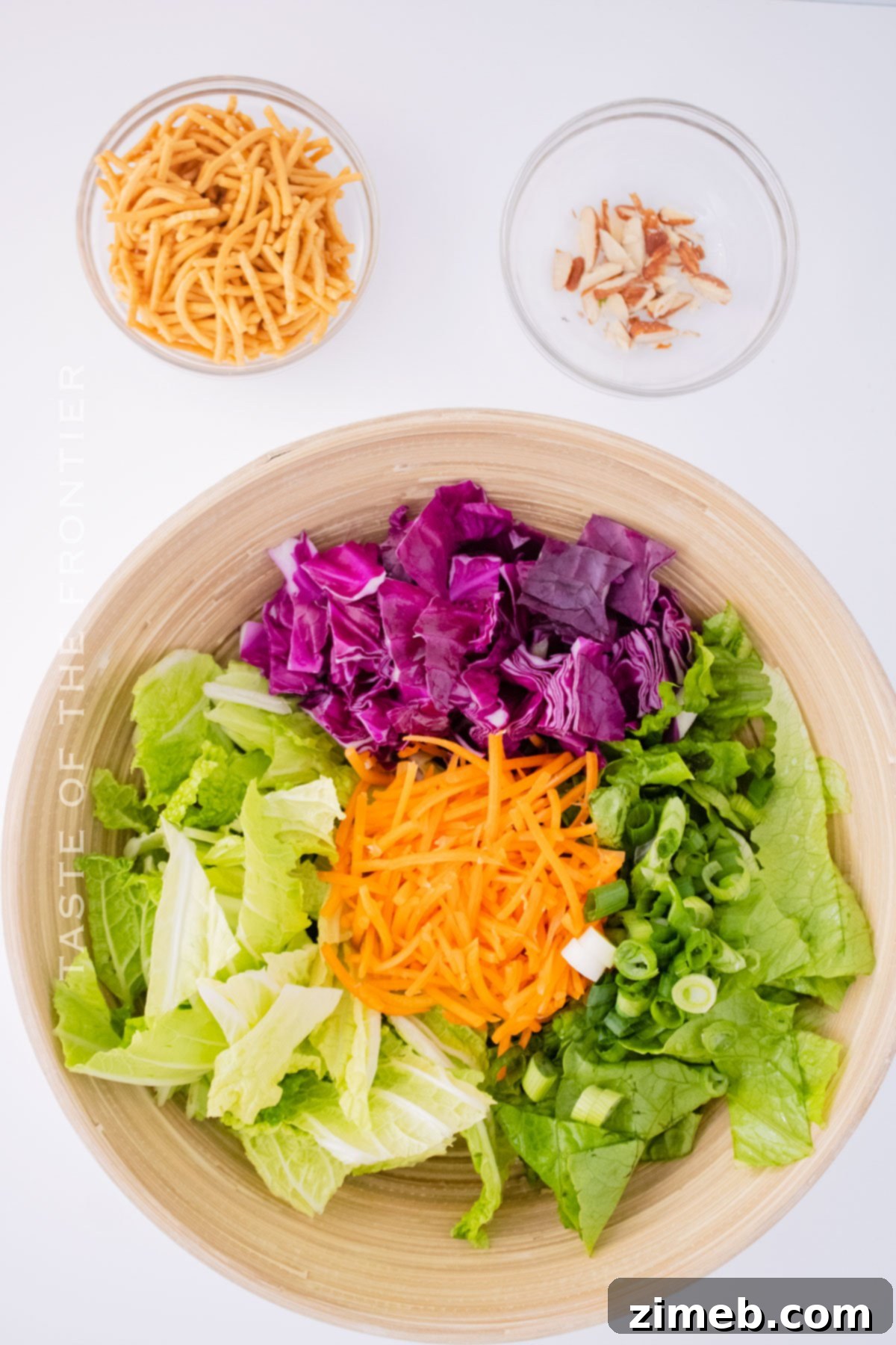 Close-up of a large bowl of Applebee's Copycat Oriental Chicken Salad being mixed with creamy dressing.